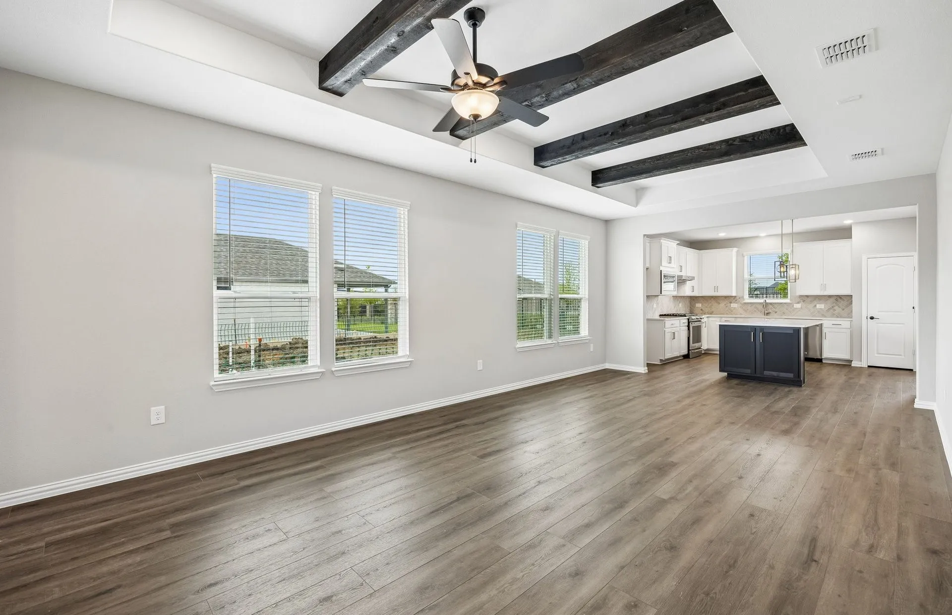 Open concept gathering room with tray ceilings
