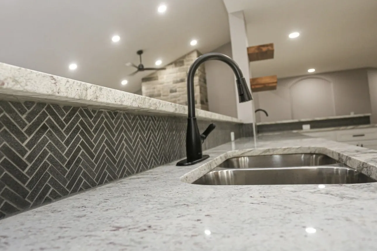 Kitchen with light stone counters, vaulted ceiling, recessed lighting, a ceiling fan, and decorative backsplash