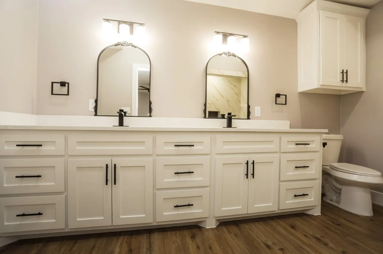 Bathroom featuring double vanity and dark wood-style flooring