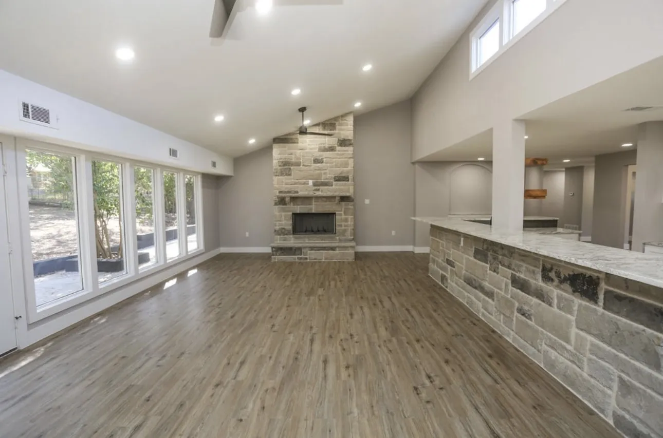 Unfurnished living room featuring high vaulted ceiling, wood finished floors, a fireplace, recessed lighting, and a ceiling fan