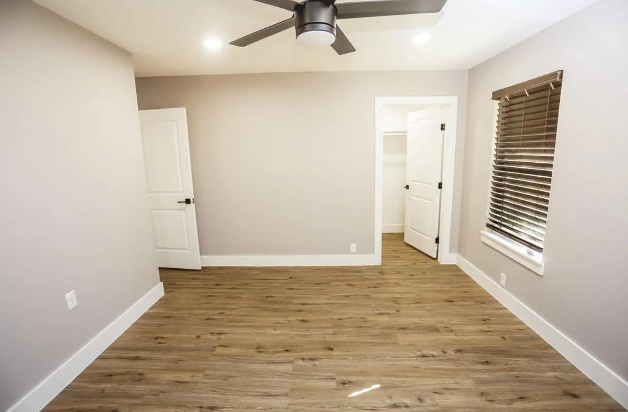 Unfurnished bedroom featuring a walk in closet, wood finished floors, recessed lighting, and ceiling fan