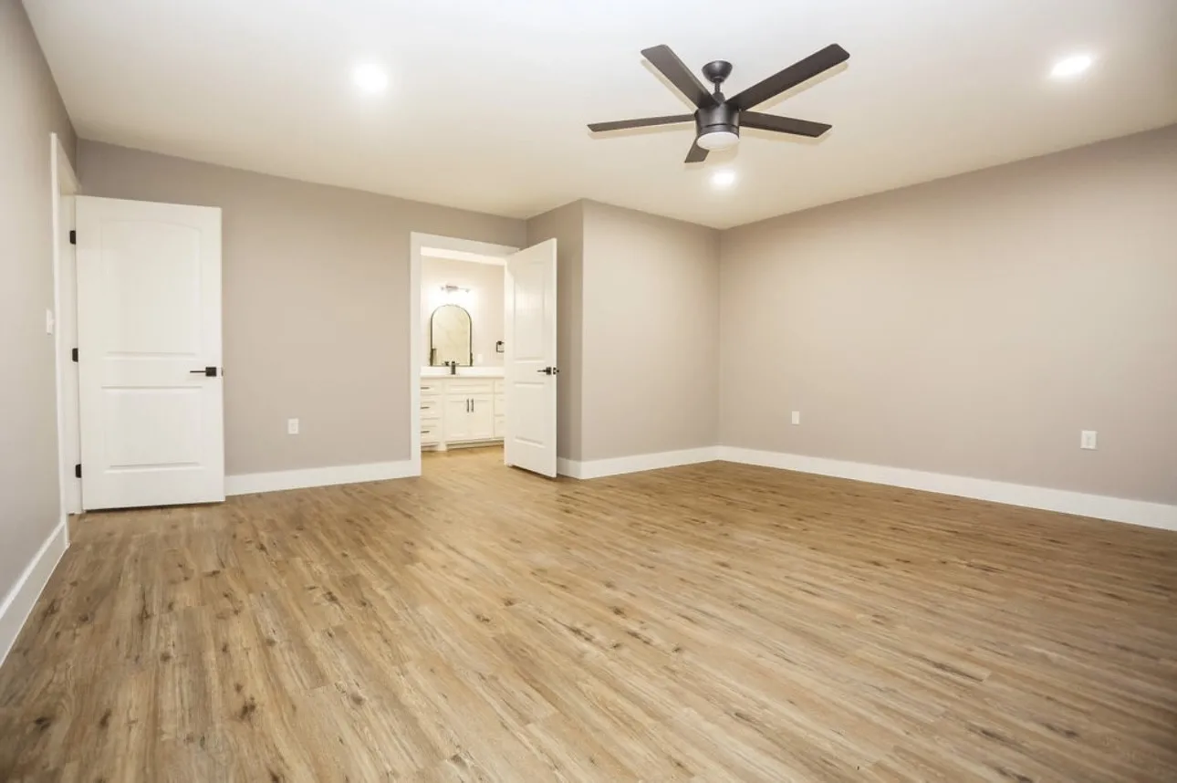 Unfurnished bedroom featuring light wood-style flooring, ceiling fan, connected bathroom, and recessed lighting