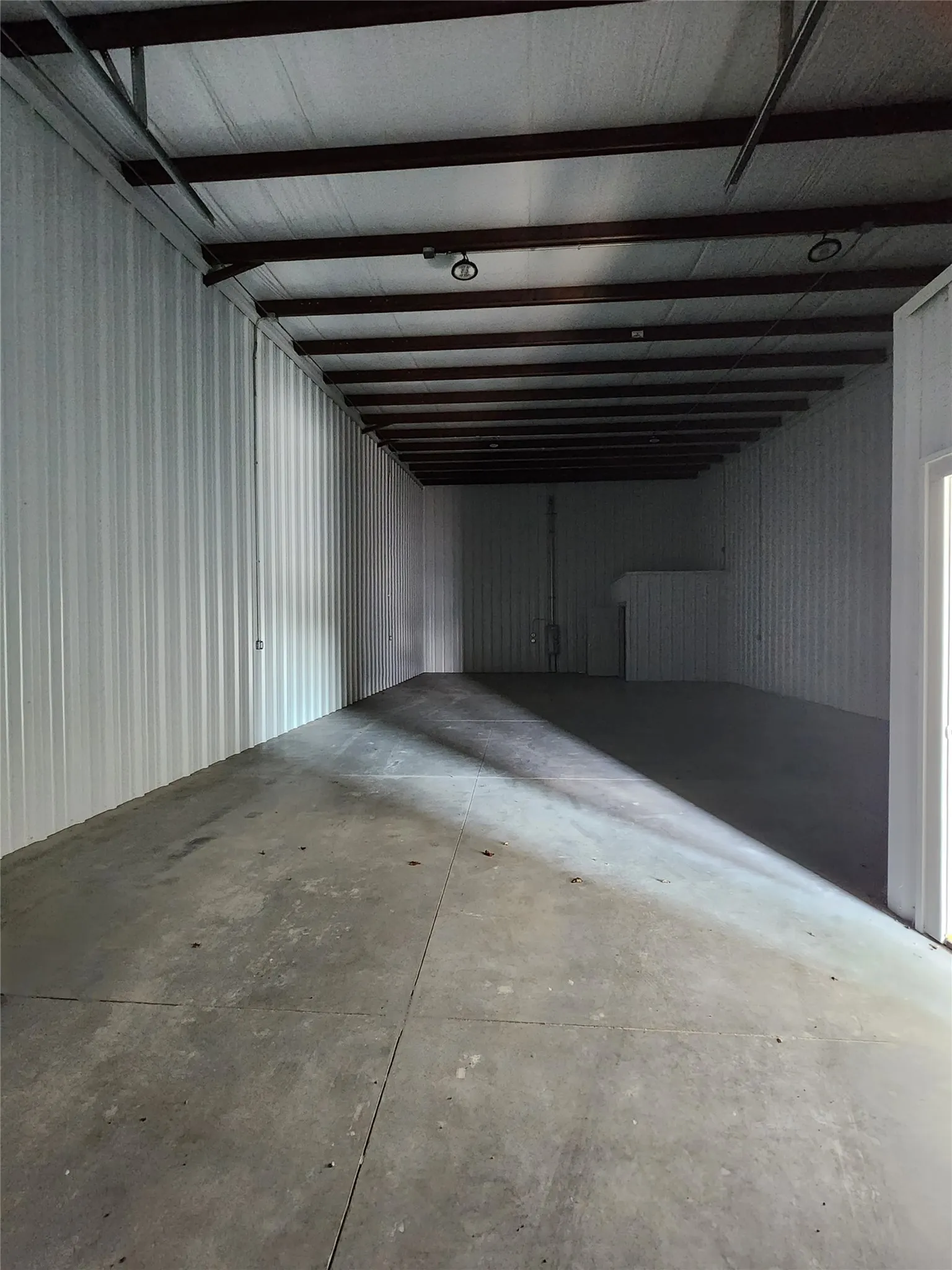 Basement featuring metal wall and a garage