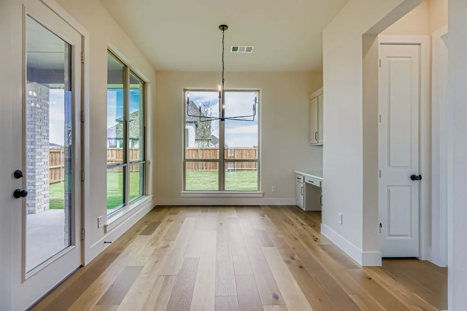 Unfurnished dining area with a chandelier, light wood-type flooring, and built in study area