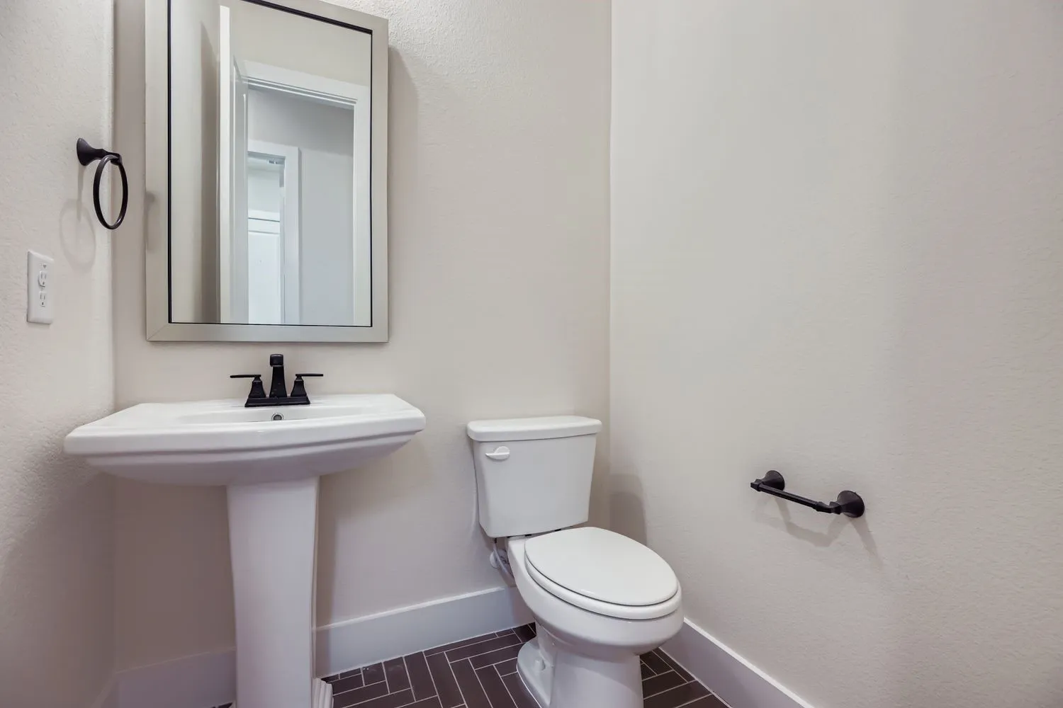Half bath with a textured wall and tile patterned flooring