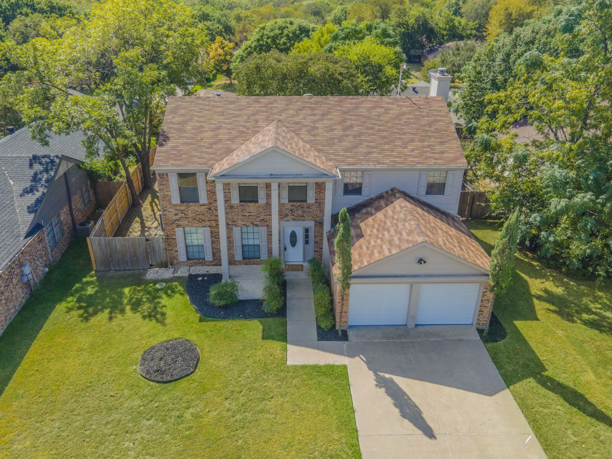 View of front of house with a garage, concrete driveway, brick siding, a shingled roof, and a chimney