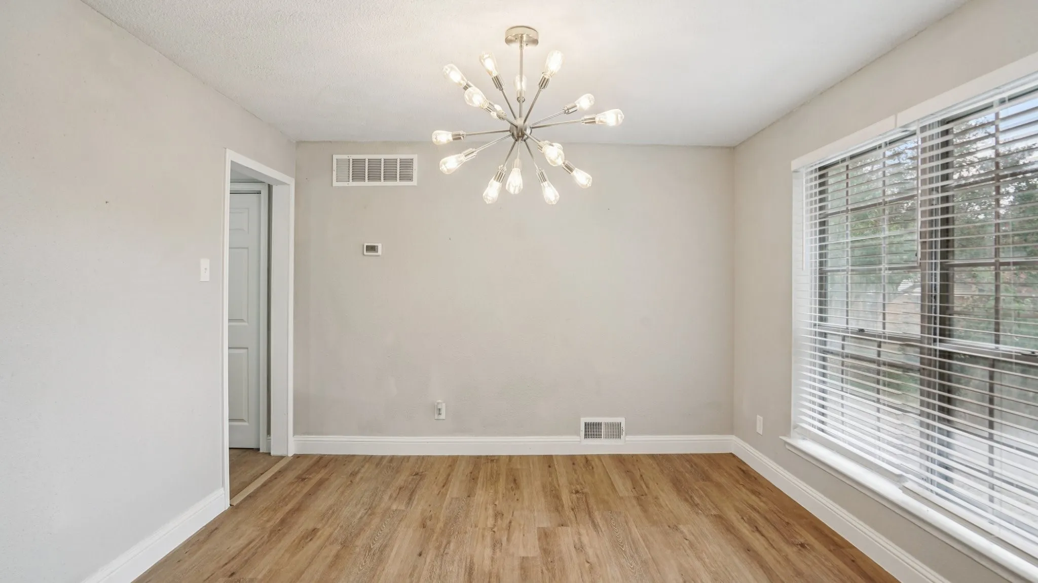 Spare room featuring light wood-style floors and a chandelier