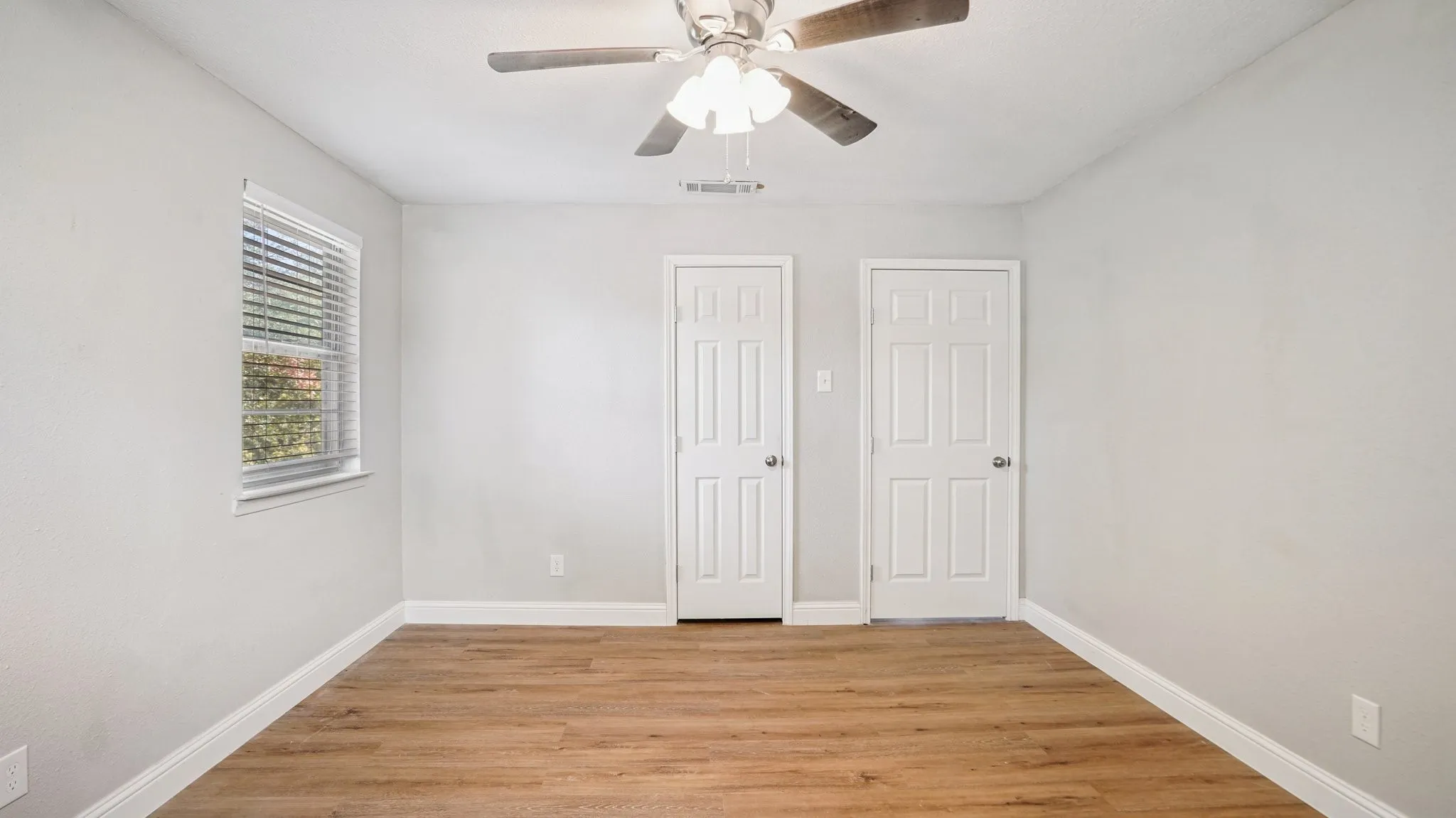 Unfurnished bedroom with light wood finished floors, ceiling fan, and a closet