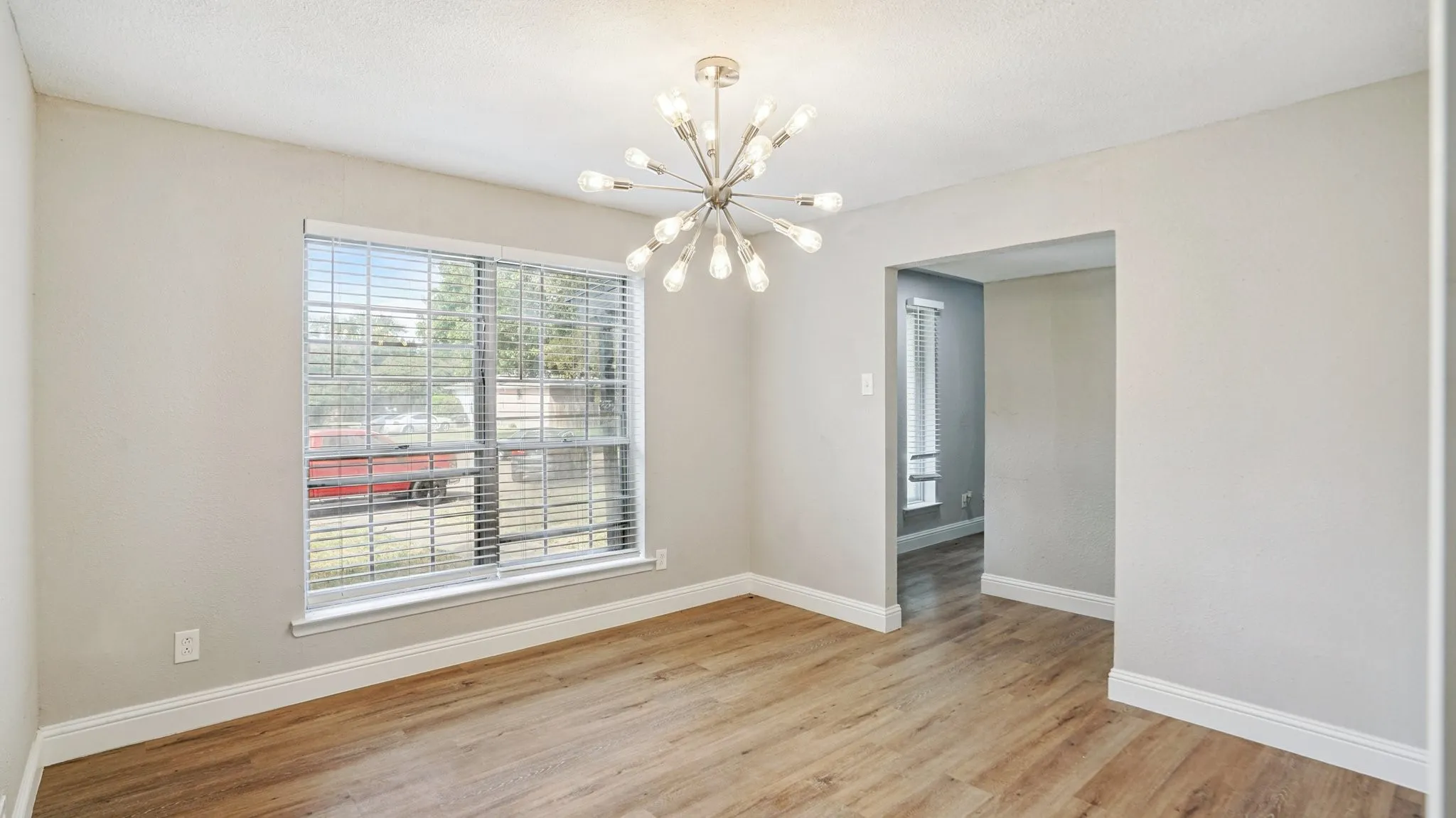 Unfurnished dining area with light wood-type flooring and a chandelier