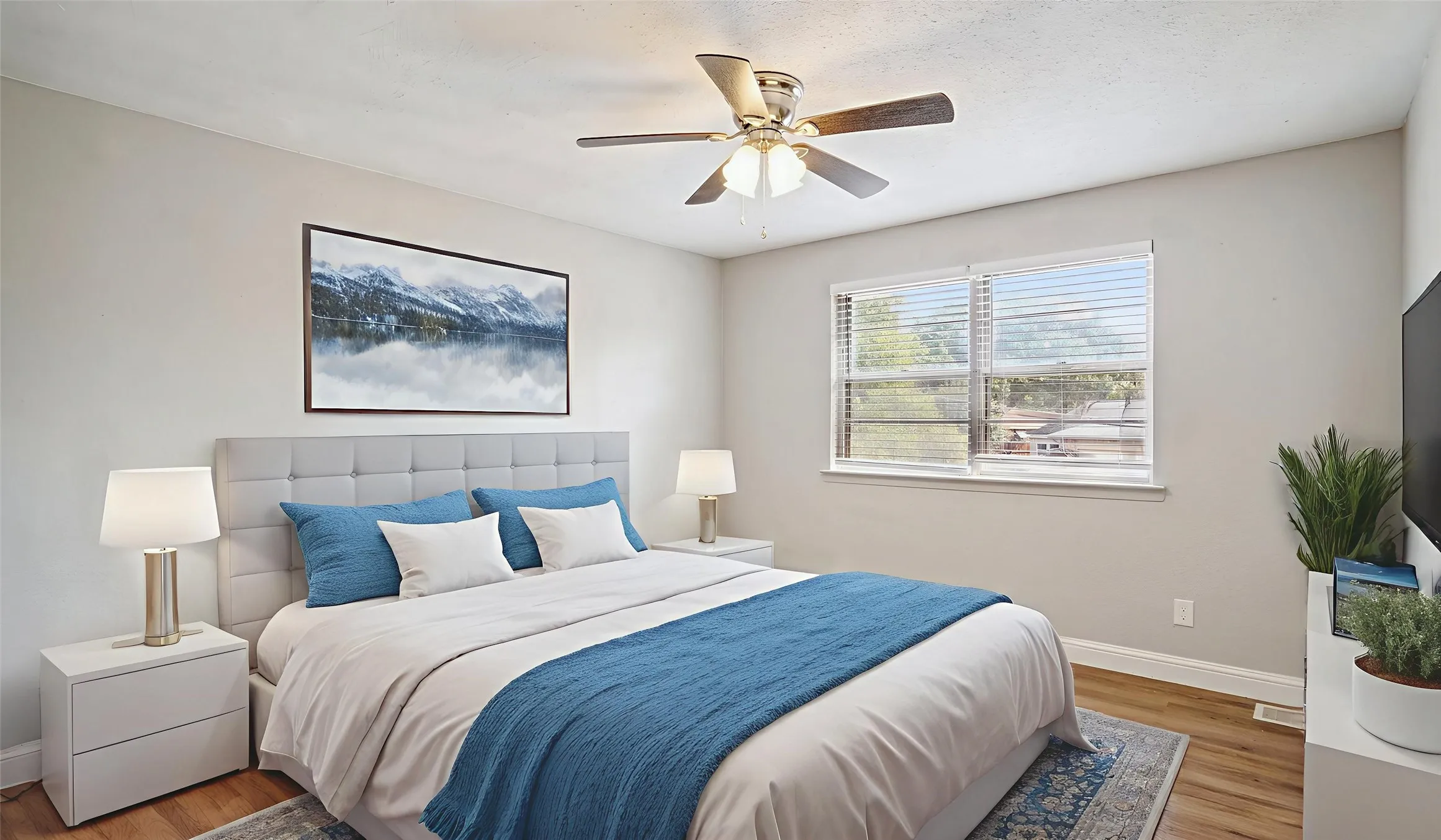 Bedroom with wood finished floors and a ceiling fan. Virtual Staged