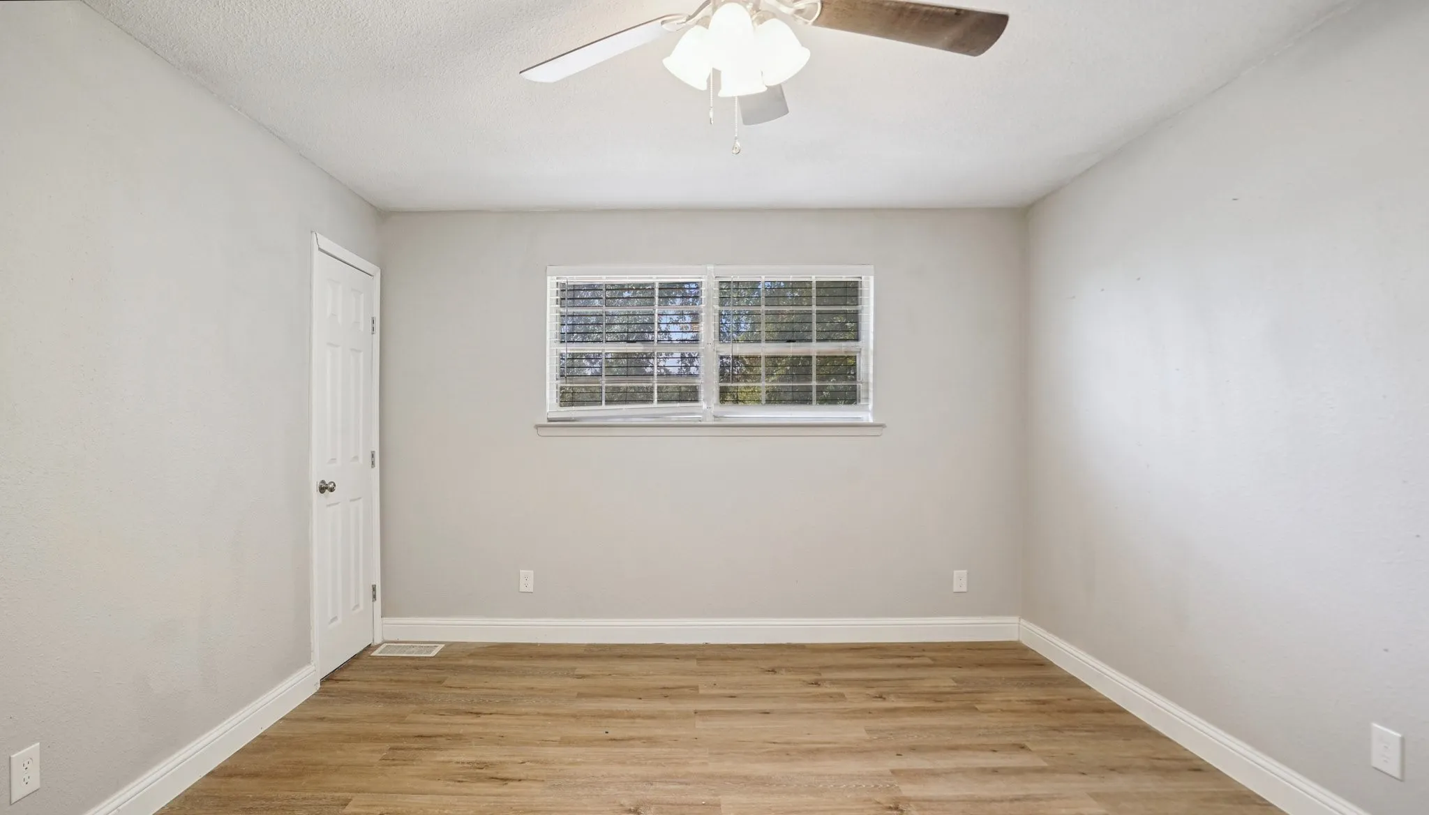 Empty room with light wood-type flooring and a ceiling fan