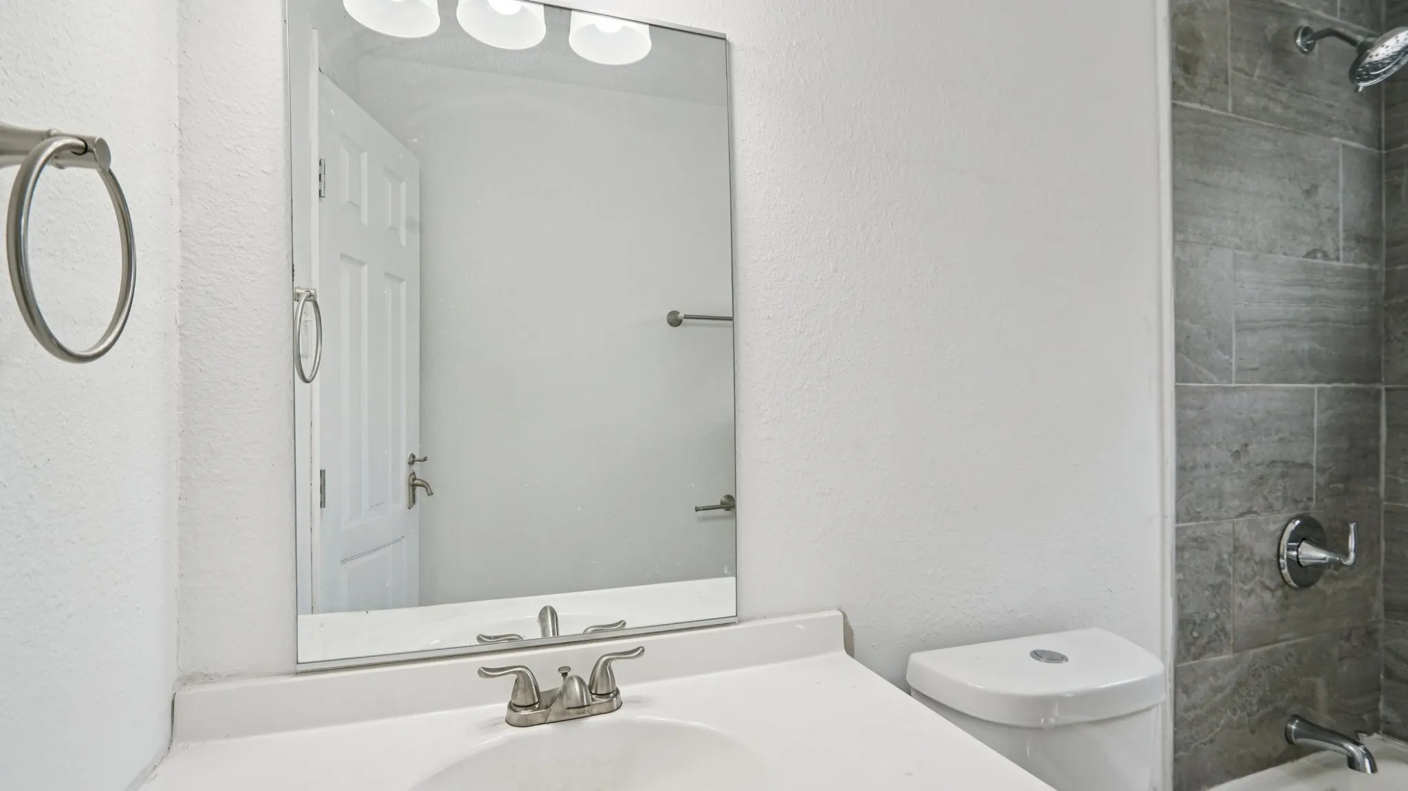Full bathroom with shower / washtub combination, vanity, and a textured wall