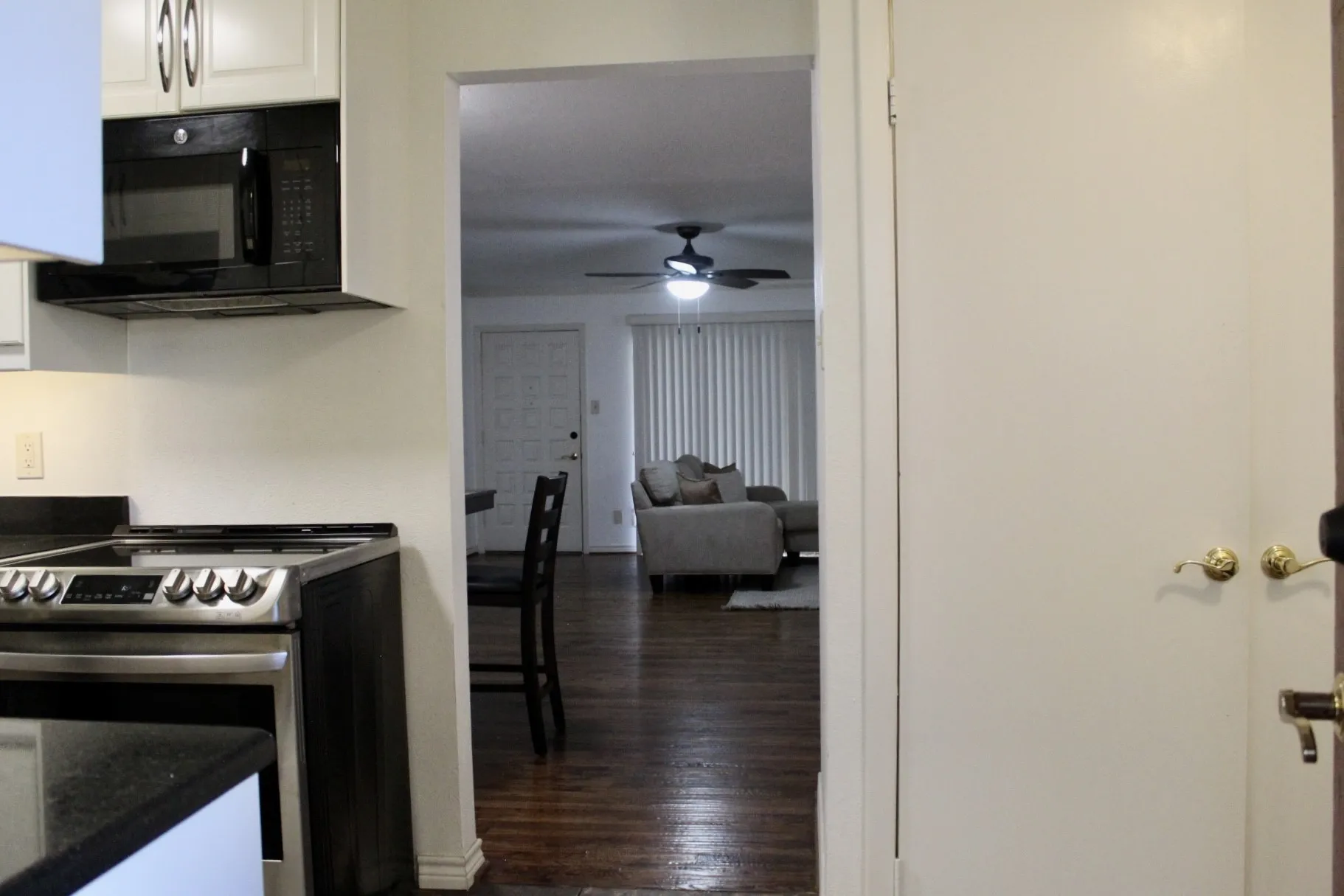 Kitchen featuring electric range, white cabinetry, dark wood finished floors, black microwave, and a ceiling fan