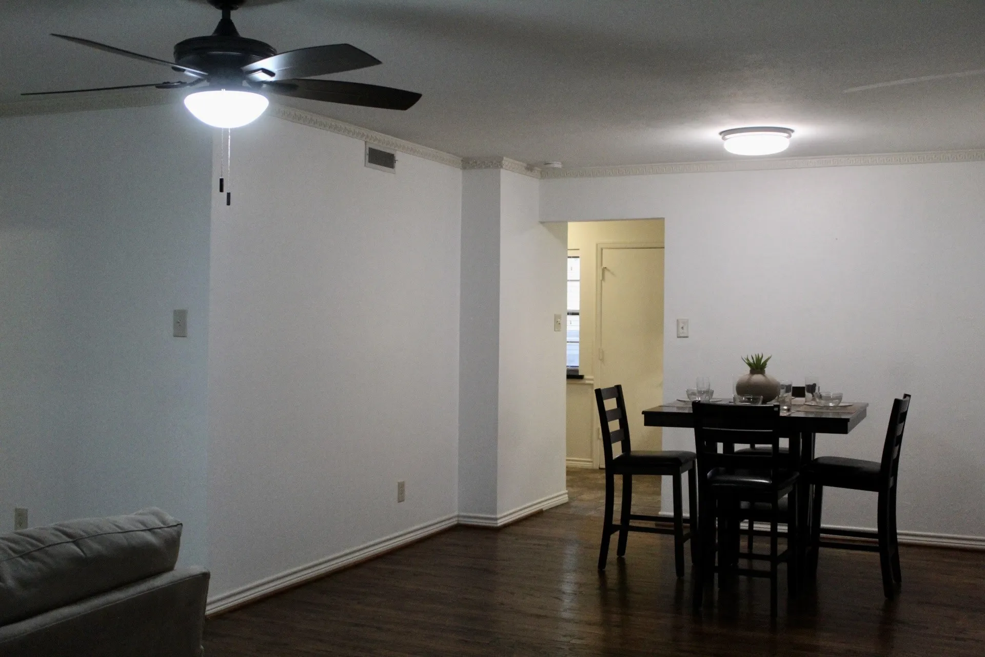 Dining area with ornamental molding, dark wood-style floors, and a ceiling fan