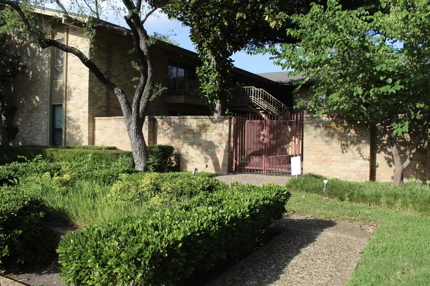 View of home's exterior with a balcony, brick siding, and a gate