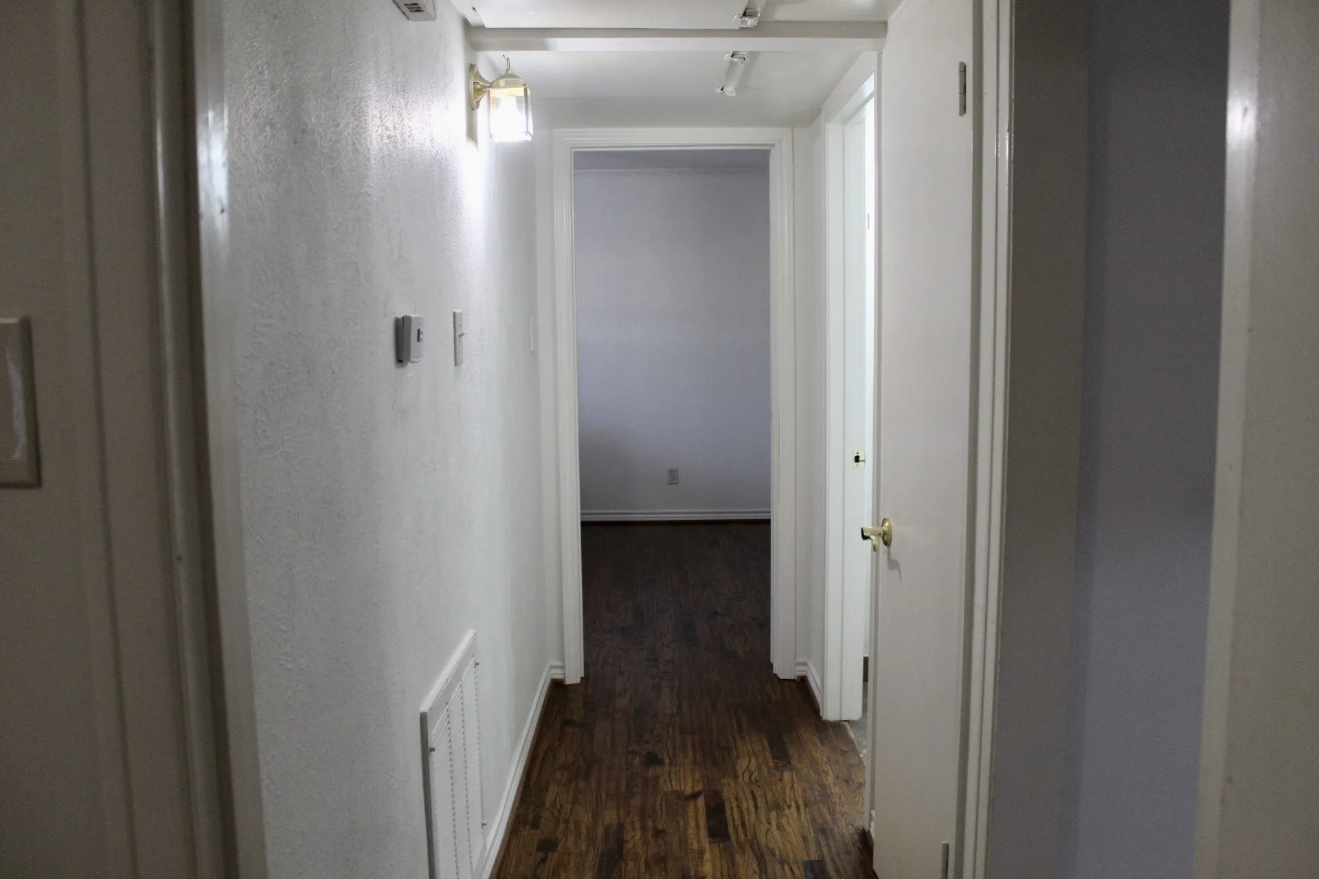 Hall with dark wood finished floors and baseboards