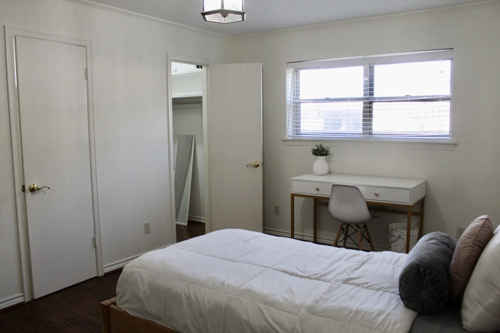 Bedroom featuring dark wood finished floors, ornamental molding, and a walk in closet