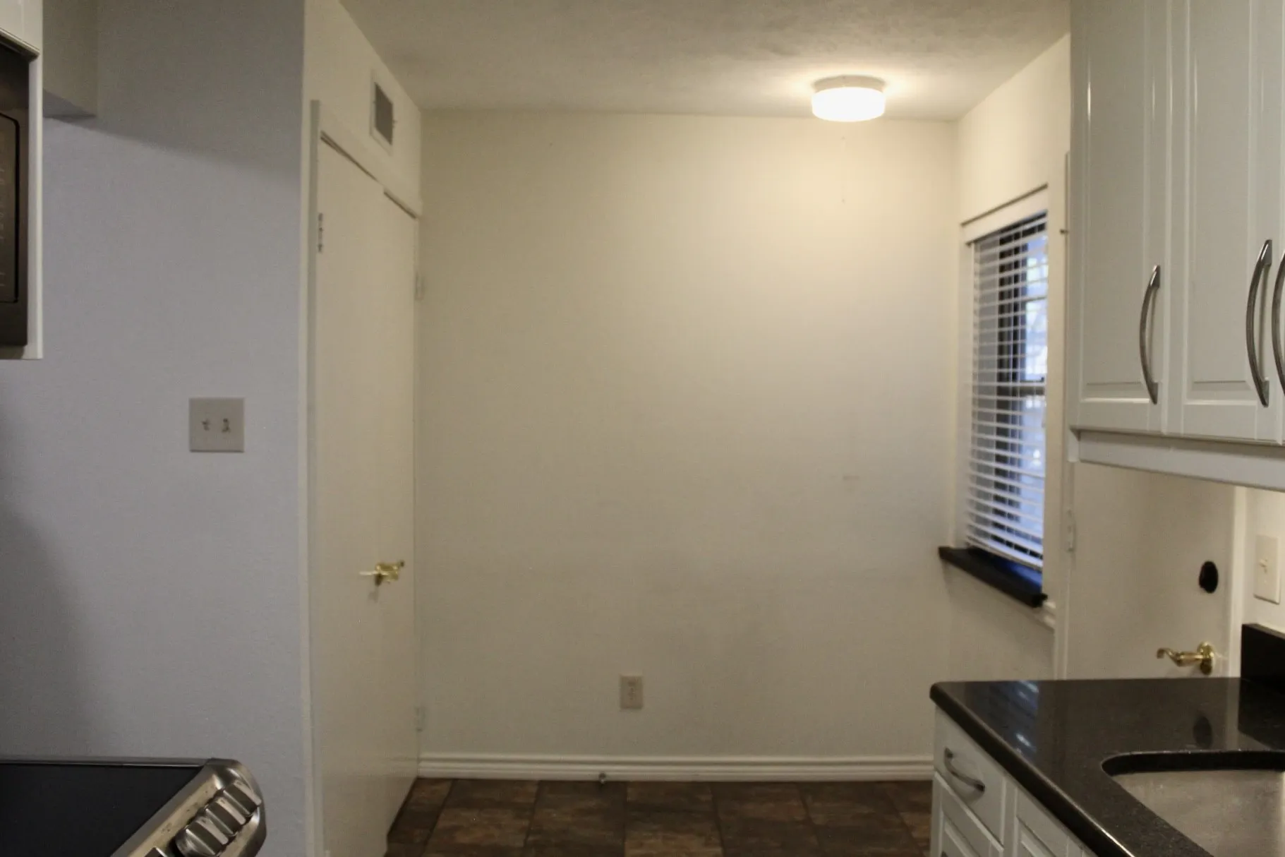 Kitchen featuring white cabinets and dark stone counters