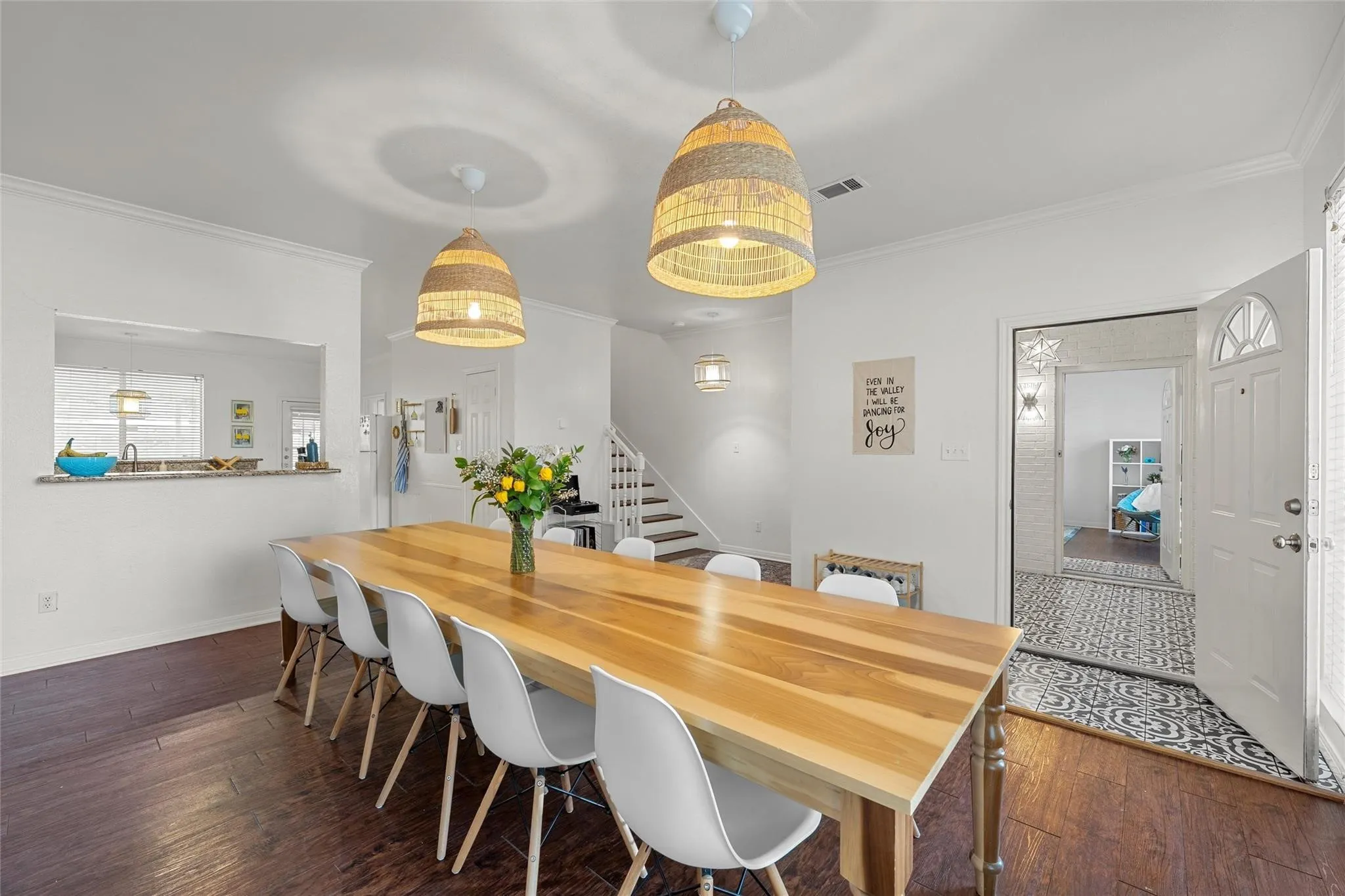 Dining room featuring dark wood finished floors, stairs, and crown molding