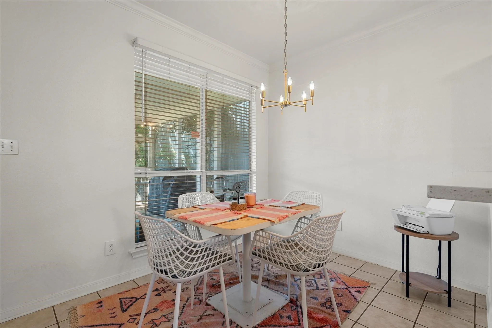 Dining space featuring light tile patterned floors, ornamental molding, and a chandelier