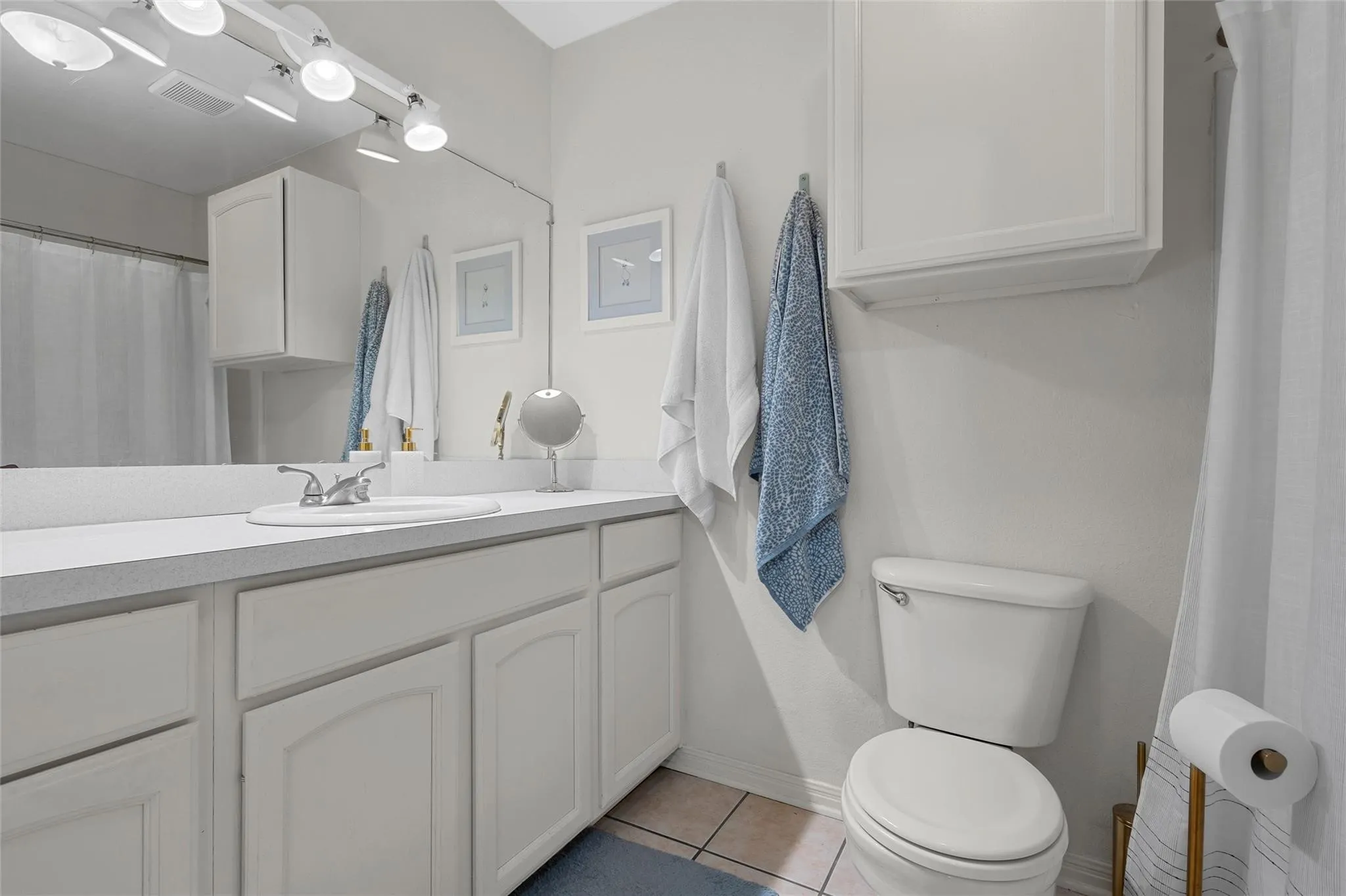 Bathroom featuring light tile patterned flooring and vanity