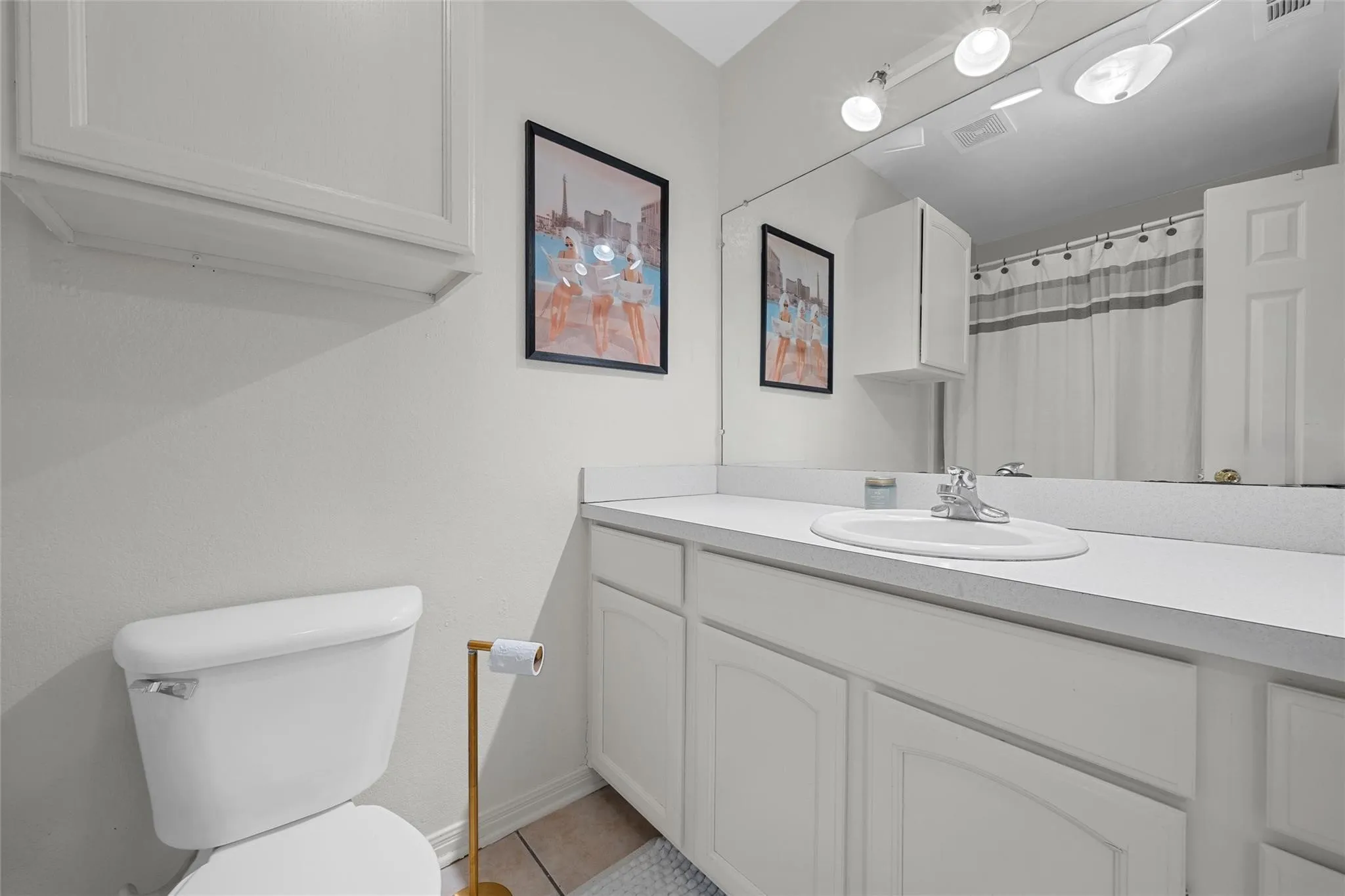 Bathroom featuring vanity, light tile patterned flooring, and a shower with curtain