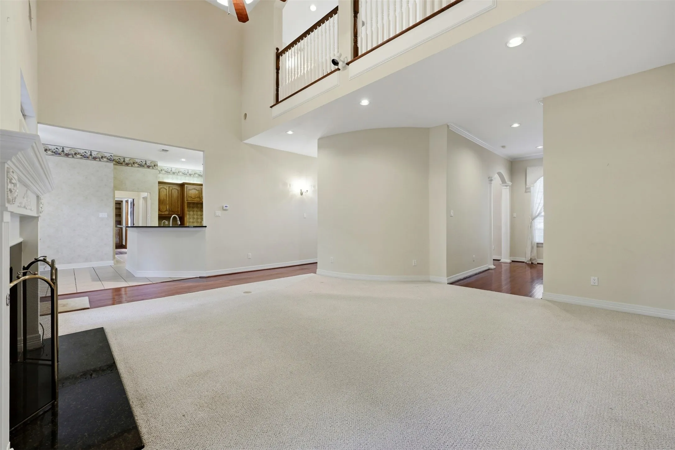living room featuring a fireplace, recessed lighting, carpet floors, and a high ceiling