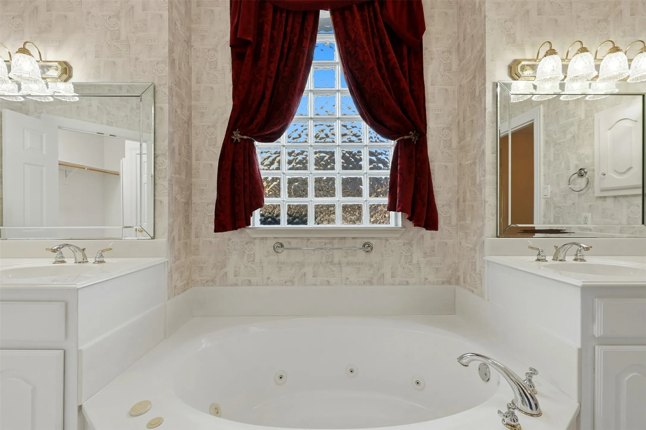 Primary Bathroom featuring wallpapered walls, a garden tub with jets, and vanity