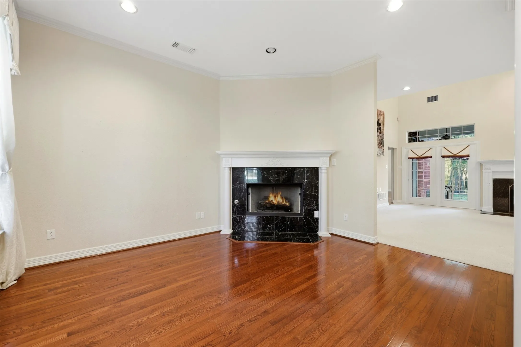 Formal living room with a high end fireplace, hardwood / wood-style floors, recessed lighting, and crown molding