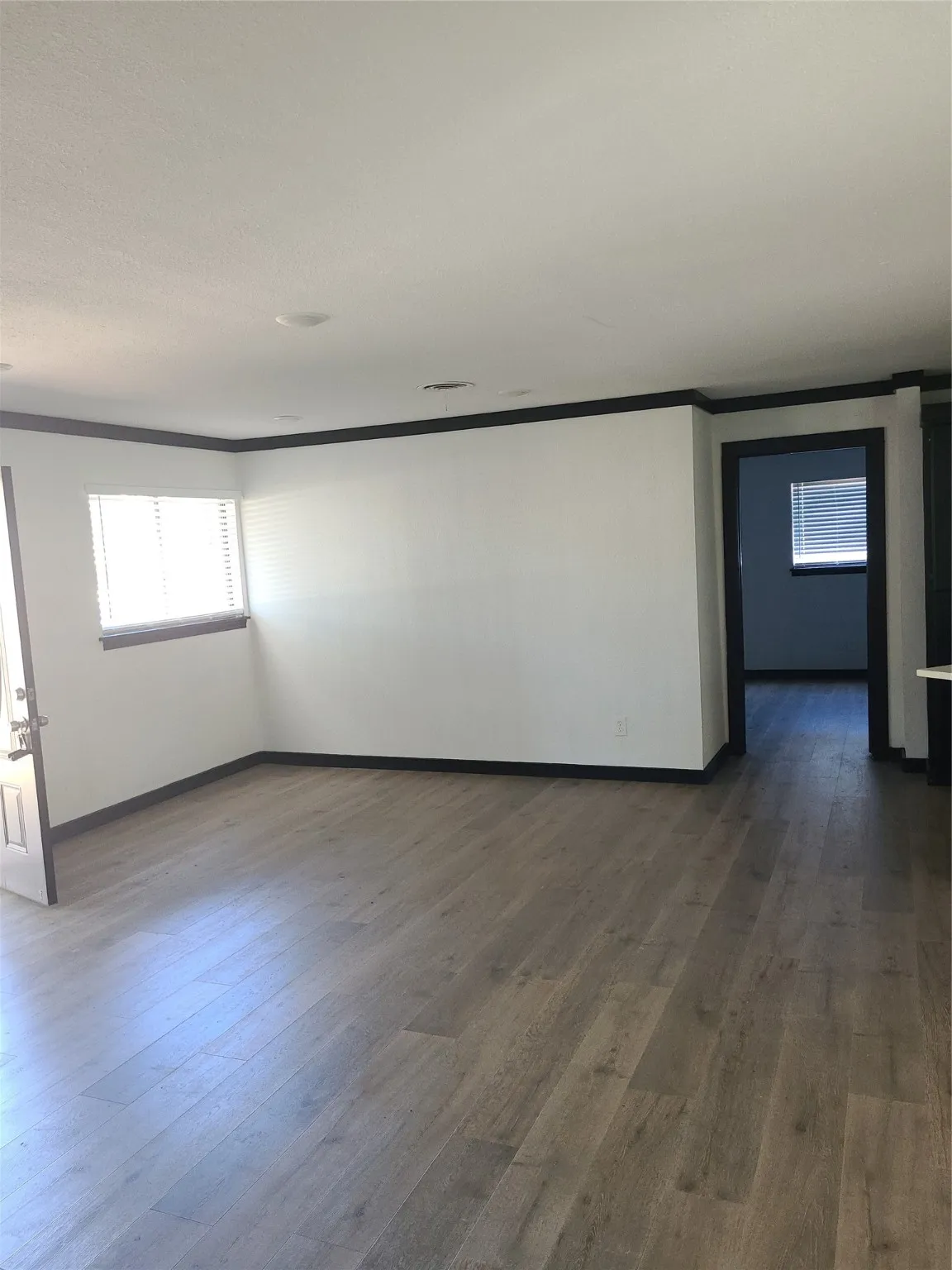 Spare room with dark wood-type flooring and crown molding