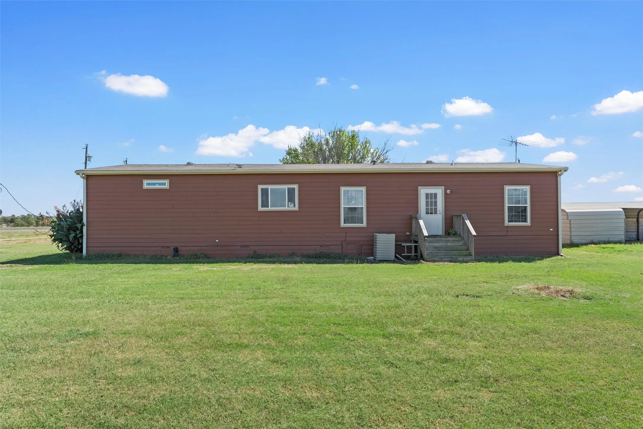 Back of property featuring a yard and entry steps