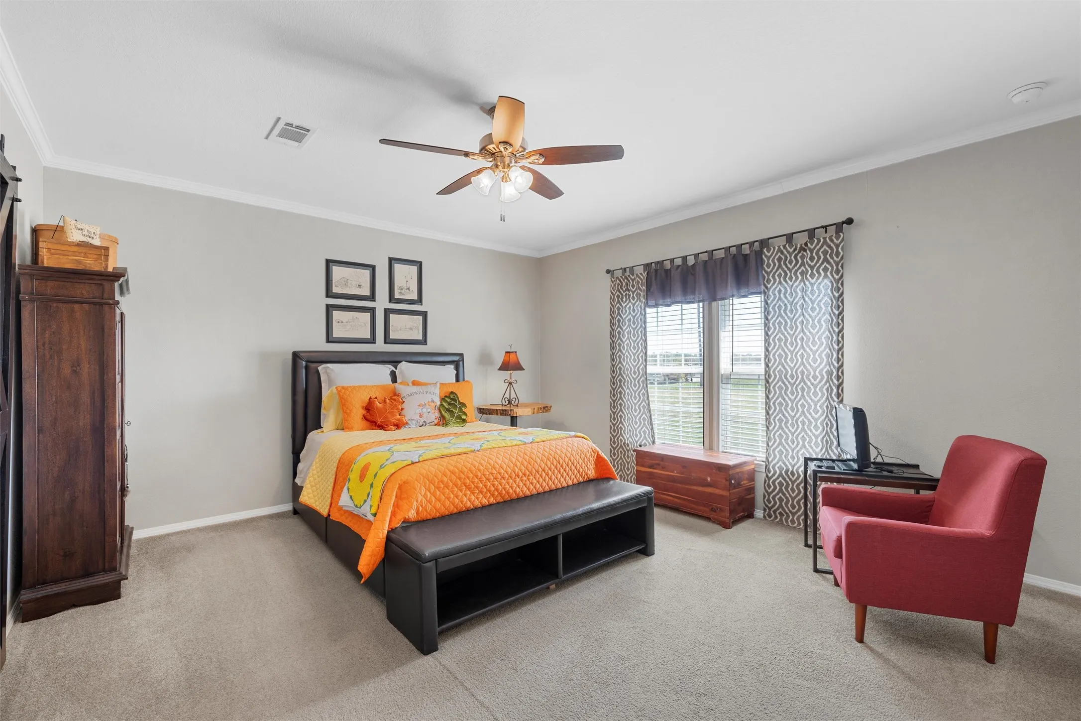 Bedroom featuring ornamental molding, light carpet, and a ceiling fan
