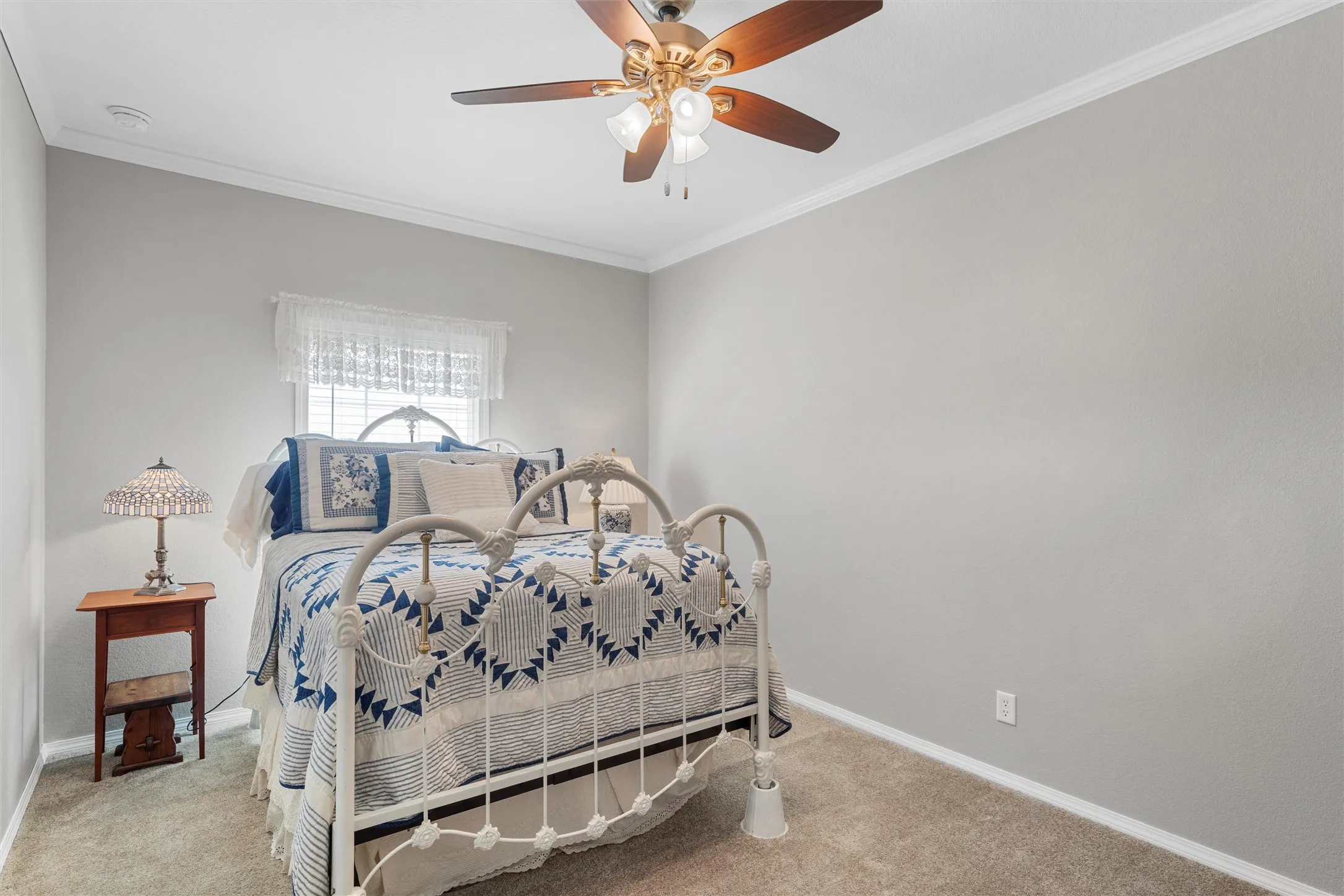 Bedroom with crown molding, carpet, and ceiling fan