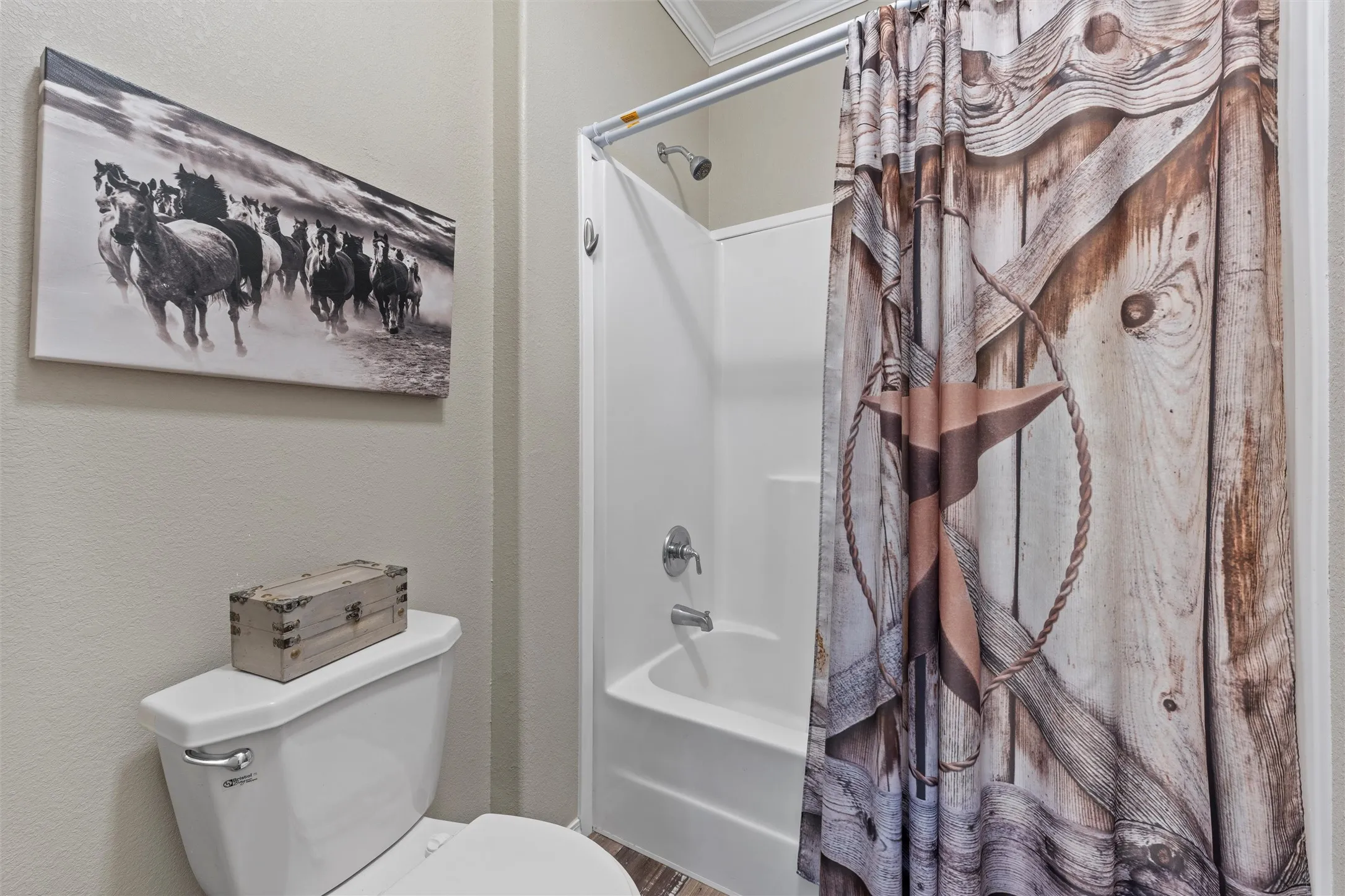 Bathroom featuring shower / tub combo with curtain, a textured wall, and ornamental molding