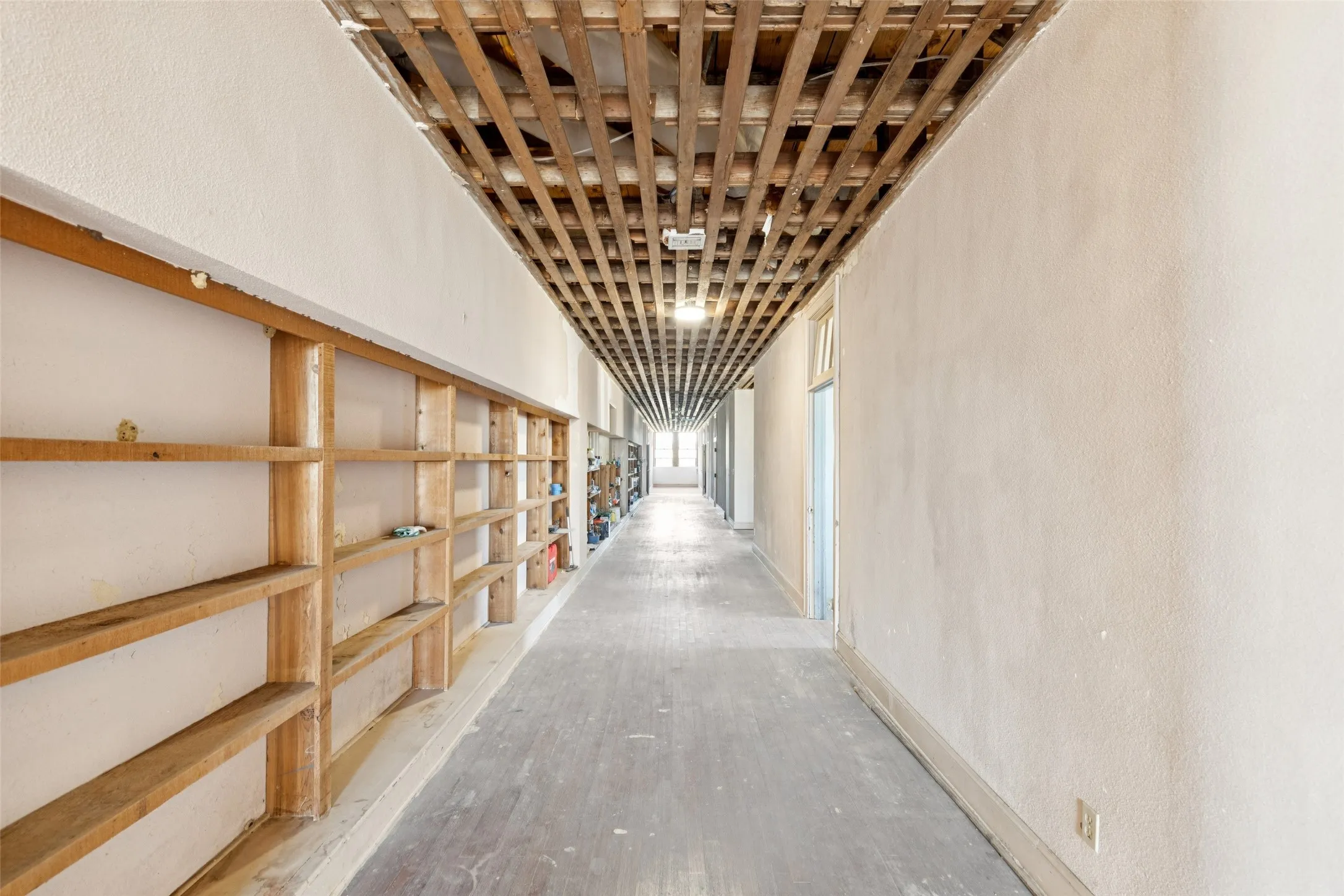 Hallway with wood finished floors and a textured wall