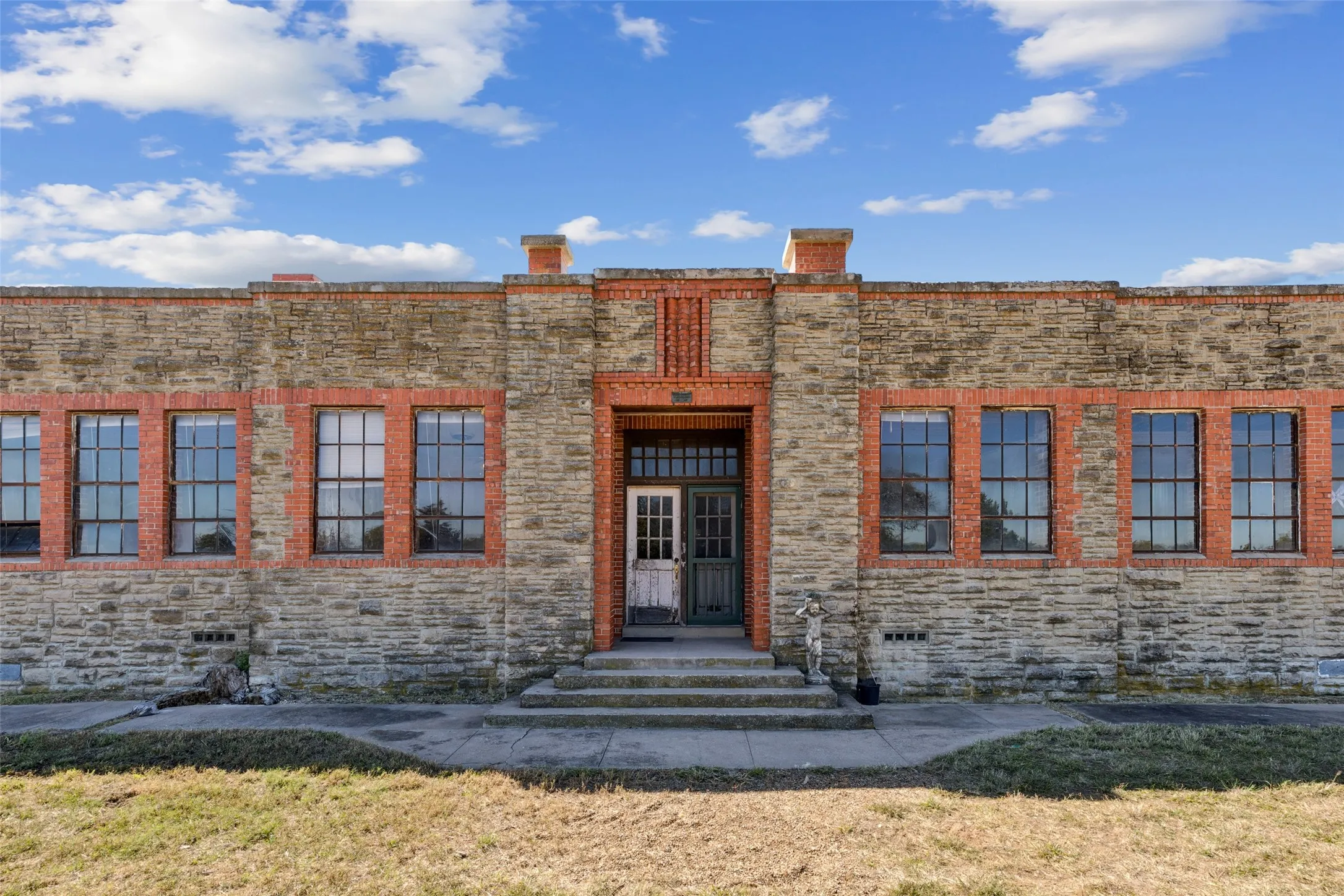 Property entrance with stone siding and a yard