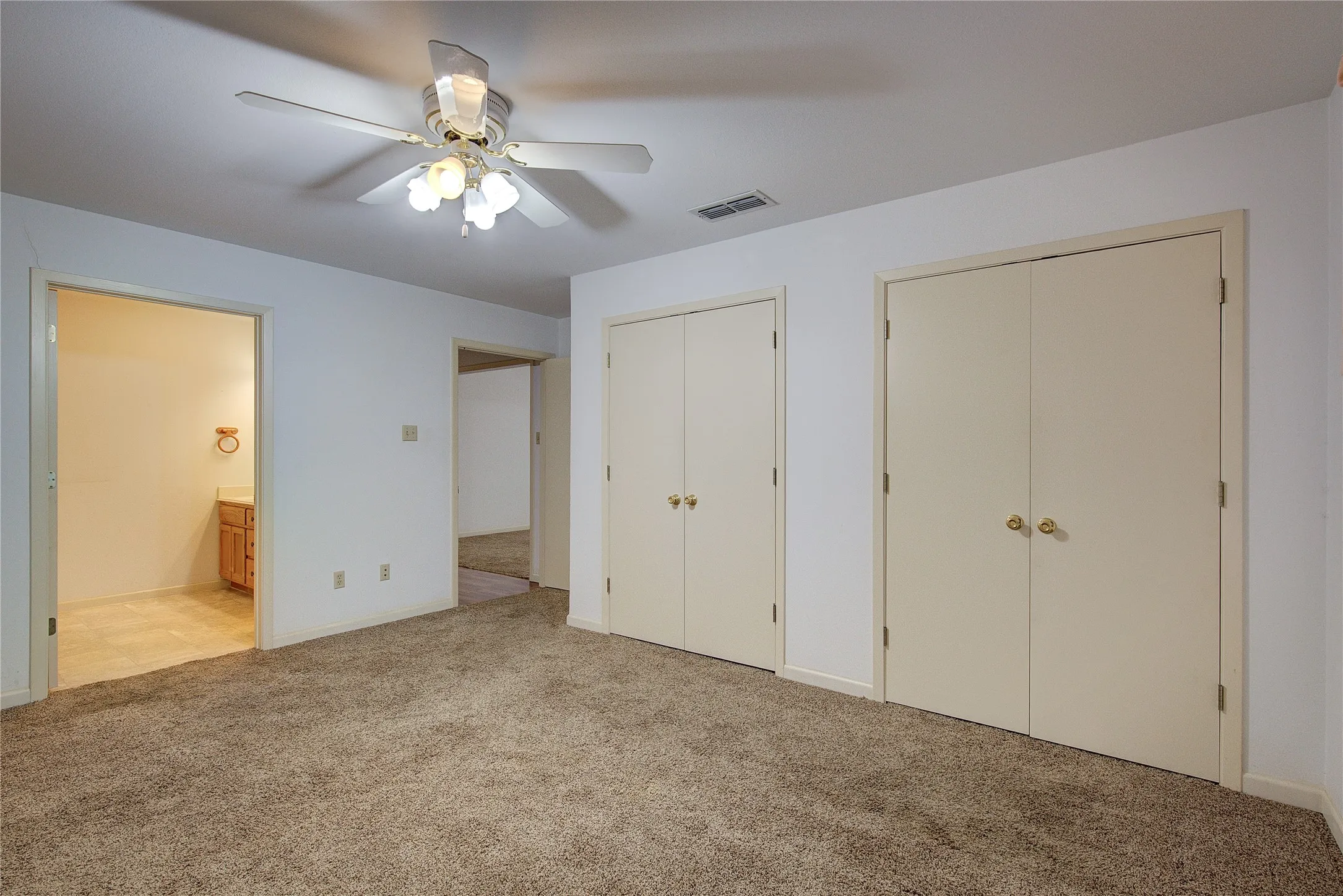 Primary bedroom with dual closets and ensuite bath