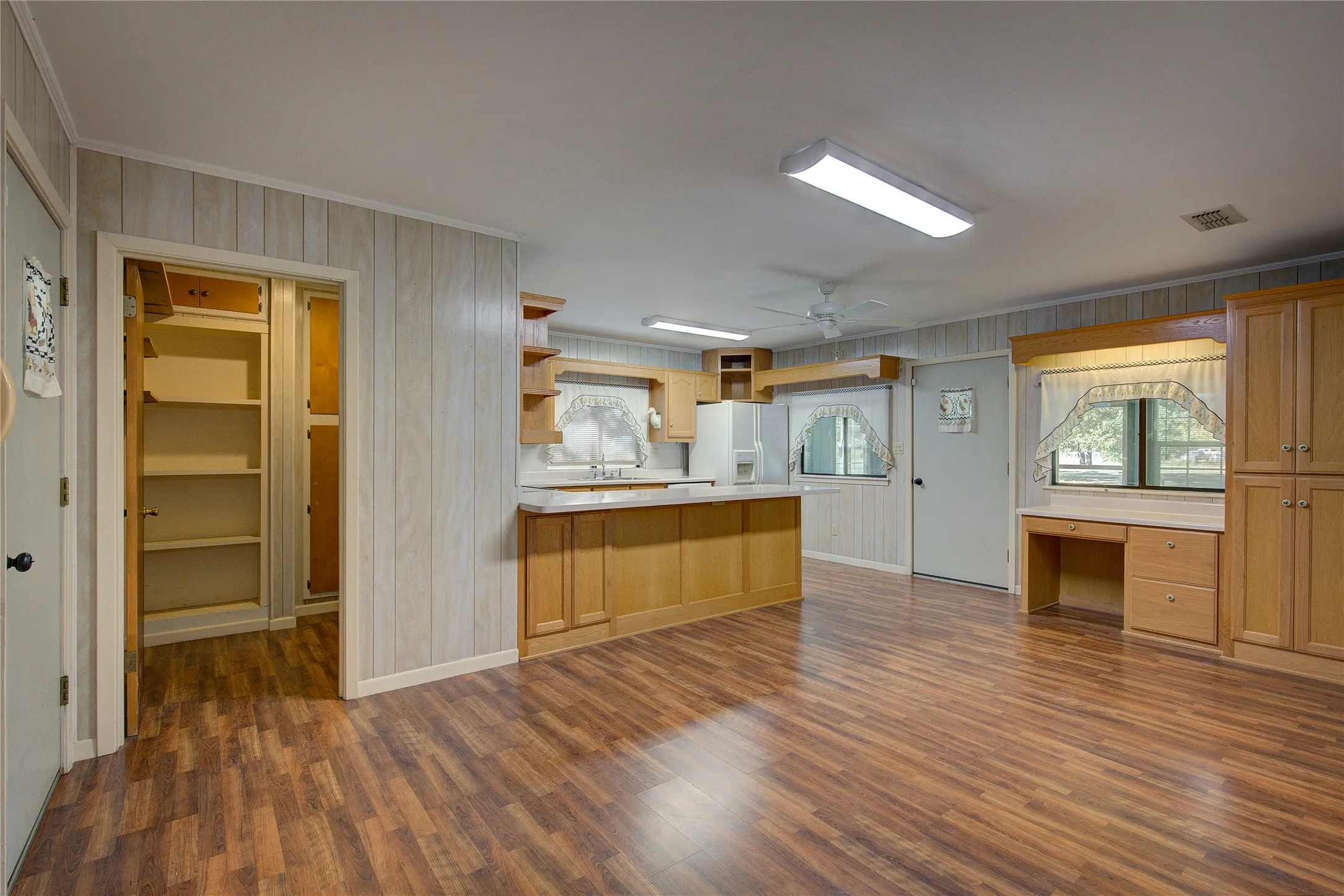 Large dining area has homework desk in corner, open to kitchen and utility.