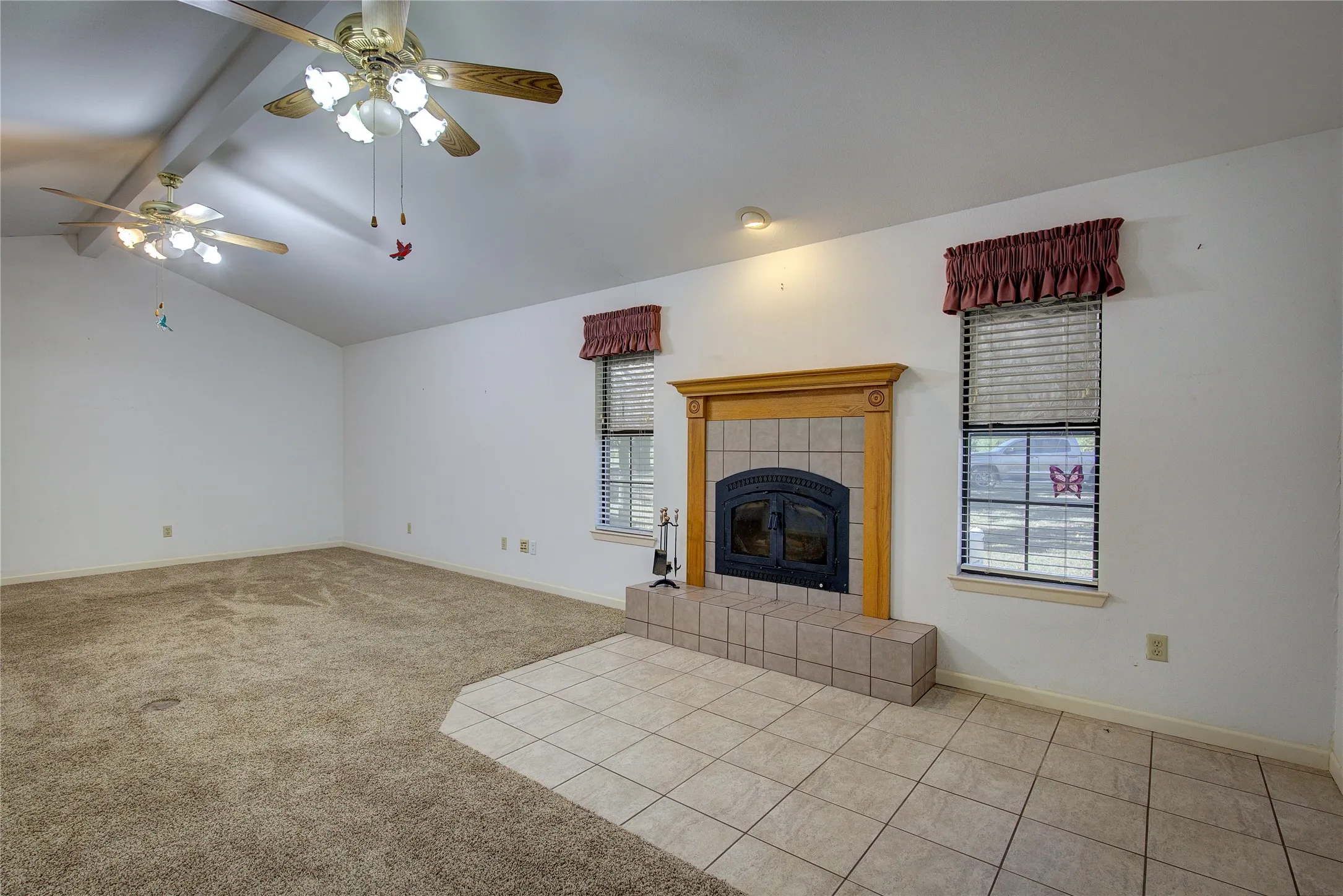 Living room with vaulted ceiling, tiled entry, two ceiling fans