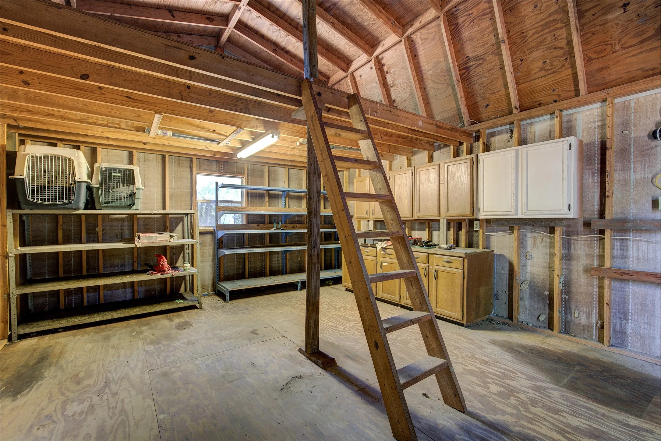 Interior of wooden workshop with shelving and loft