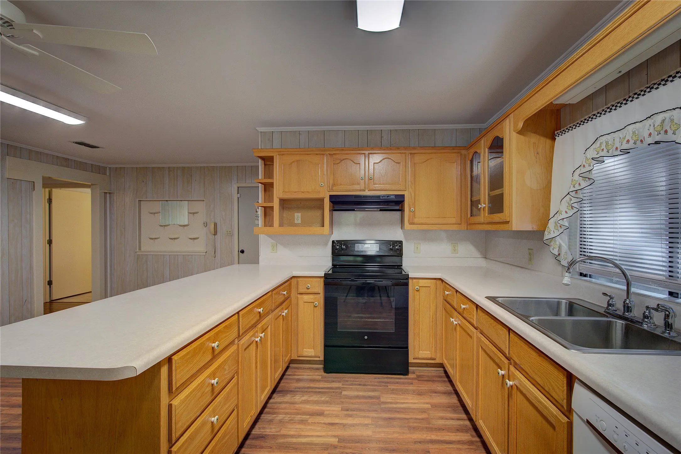 Kitchen has electric range, double sink, dishwasher, breakfast bar