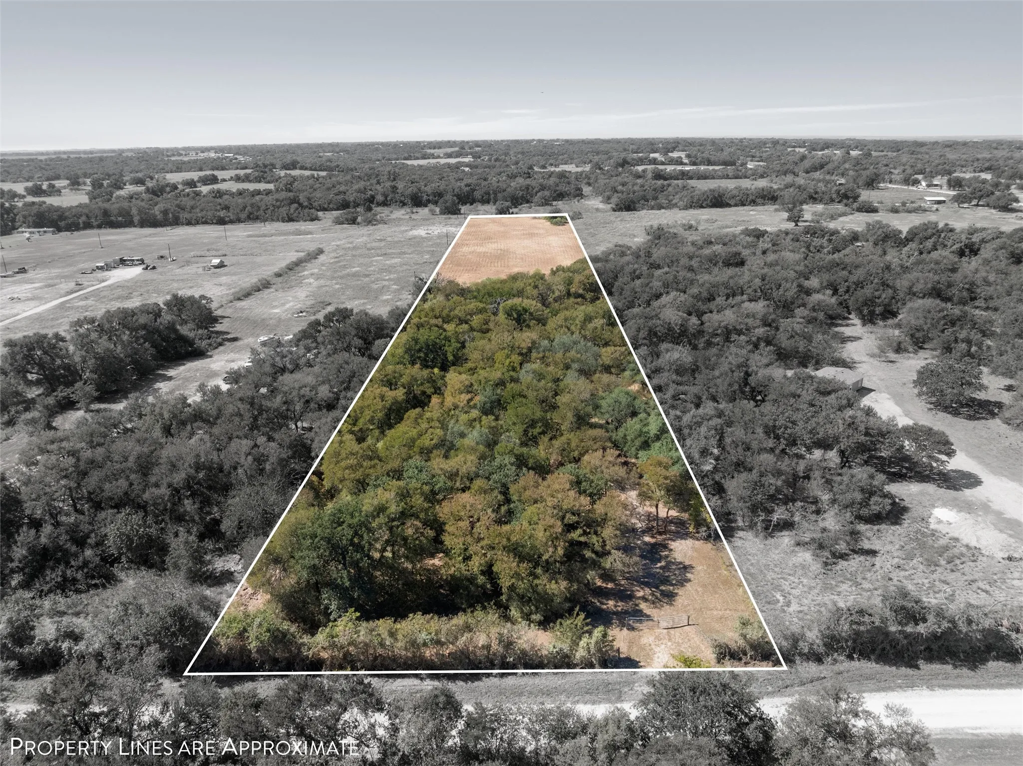 Aerial view of sparsely populated area with property parcel outlined