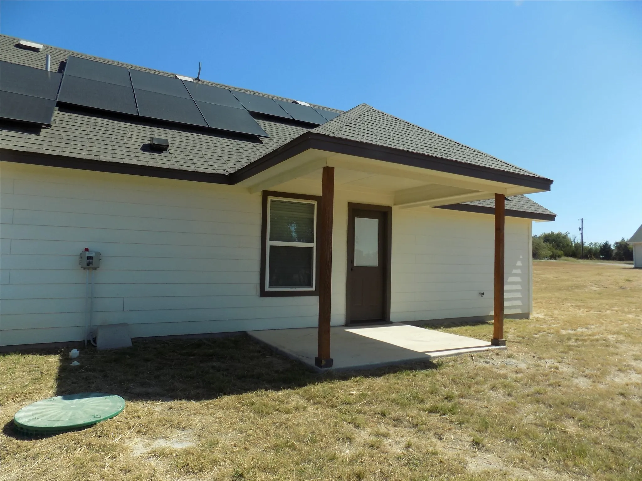 Lovely covered patio; notice the solar panels at work and a view of one of the aerobic septic system covers
