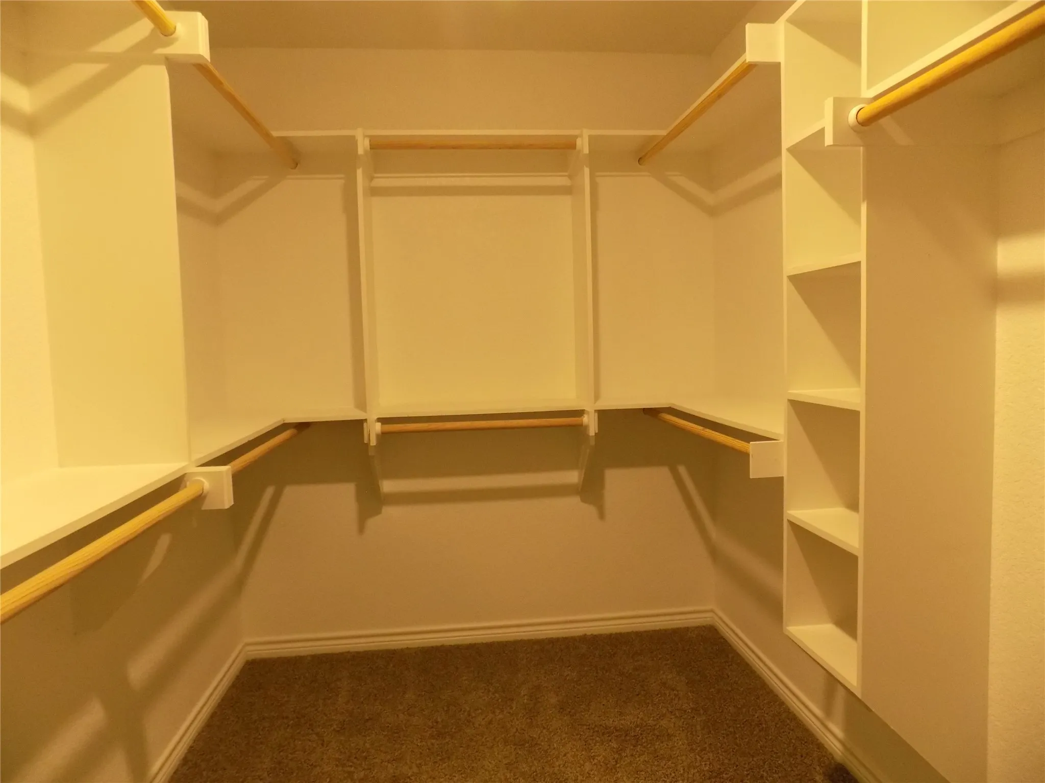 Another view of primary bedroom's walk-in closet