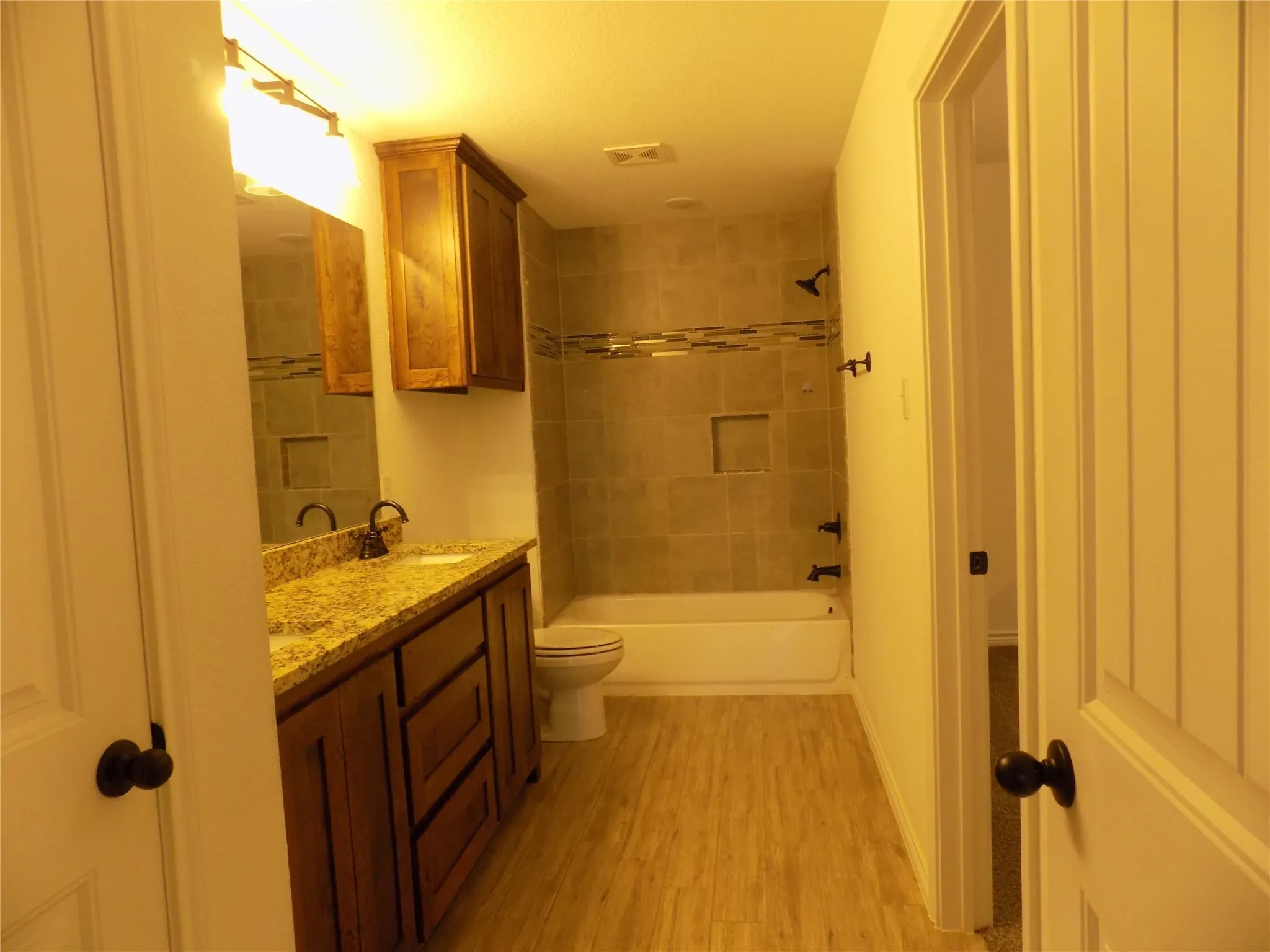 Enter into large awesome bathroom; double sinks, granite counters, extra cabinet, beautiful tile work and door to walk-in closet