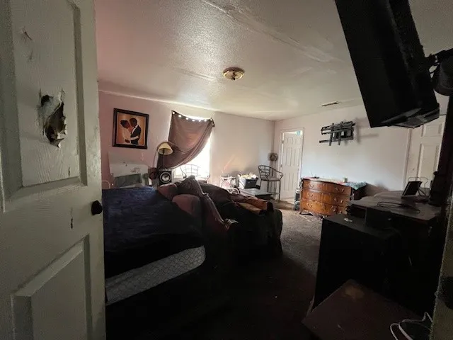 Carpeted bedroom featuring a textured ceiling