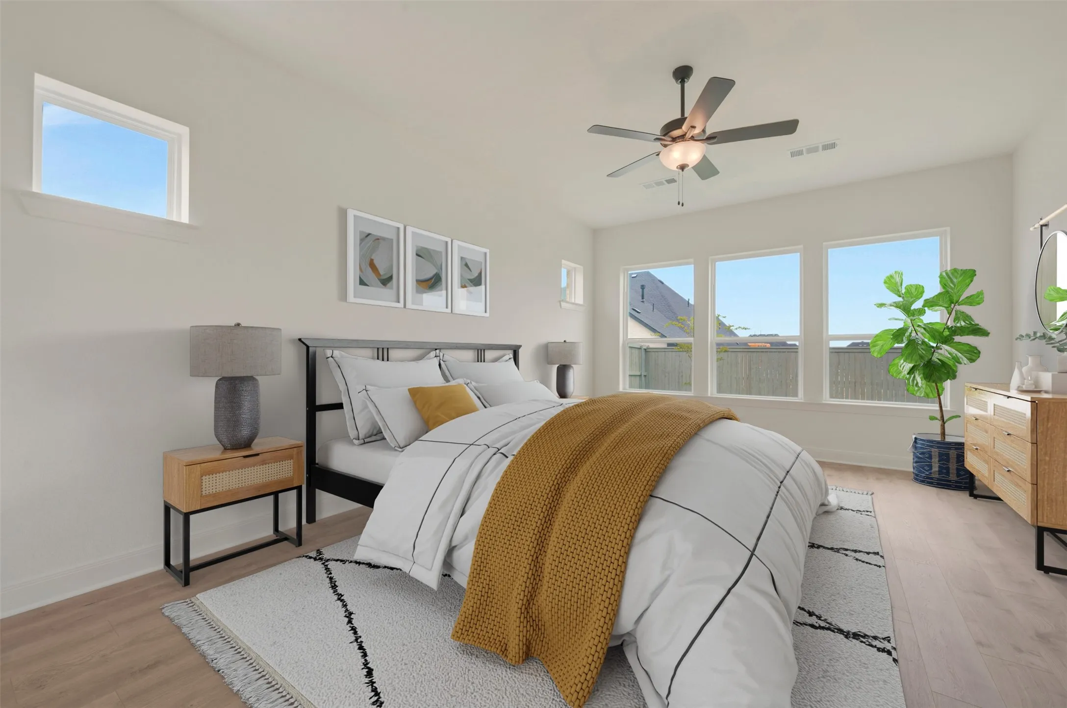 Light-filled bedroom featuring wood-finish flooring, a ceiling fan, and multiple windows