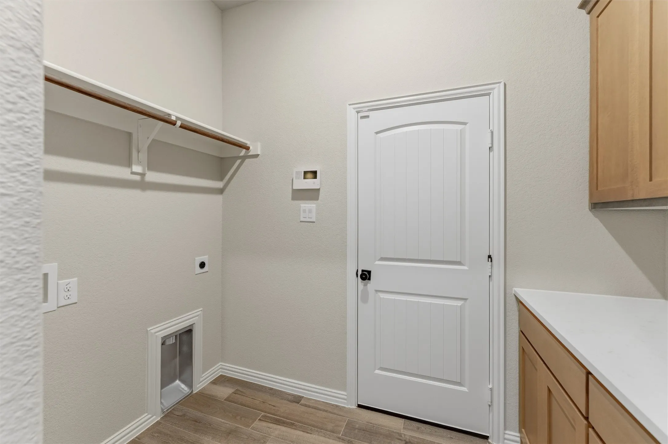 Laundry room featuring light wood-style flooring and hookup for an electric dryer