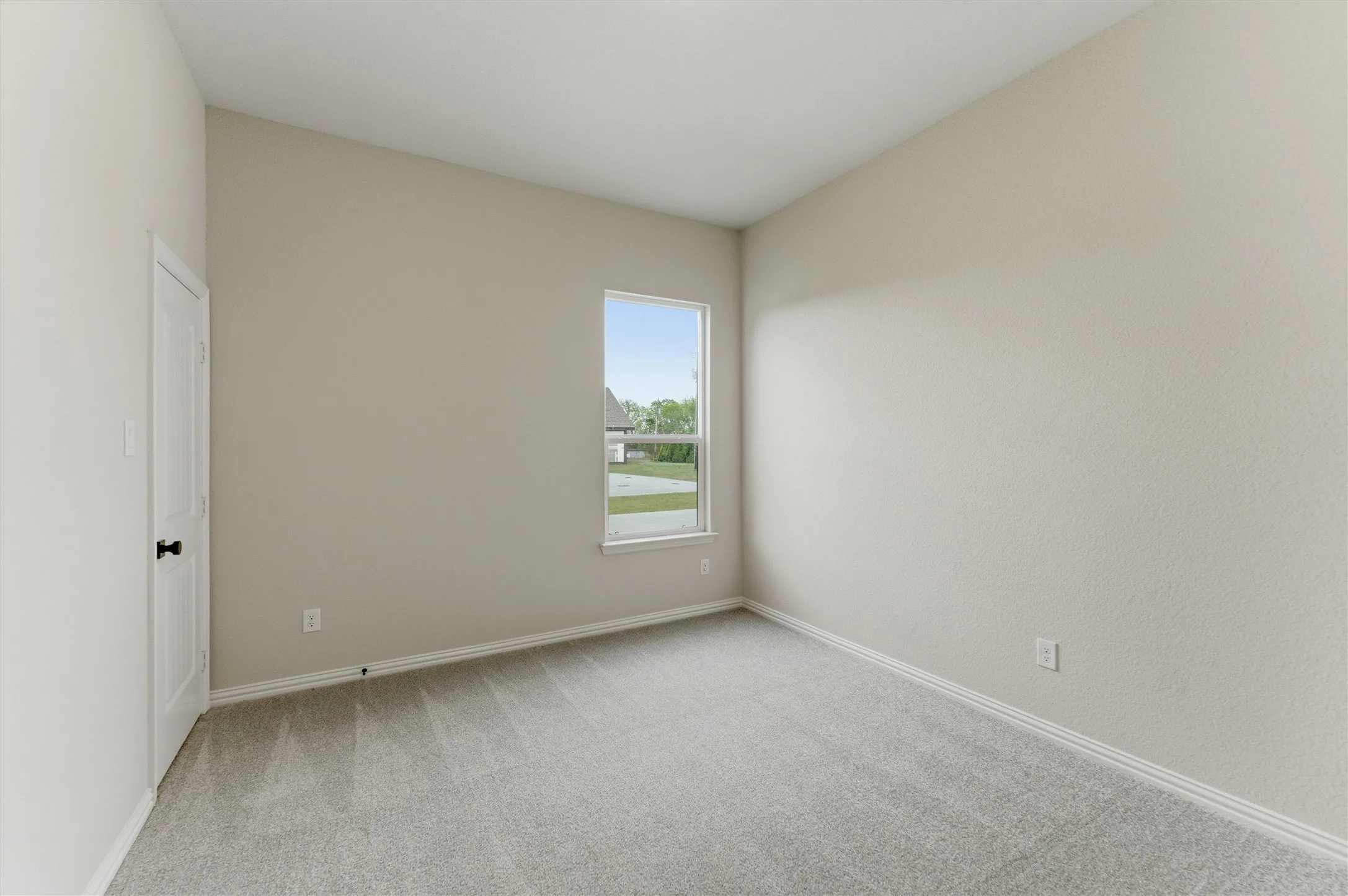 Empty room with light carpet and baseboards