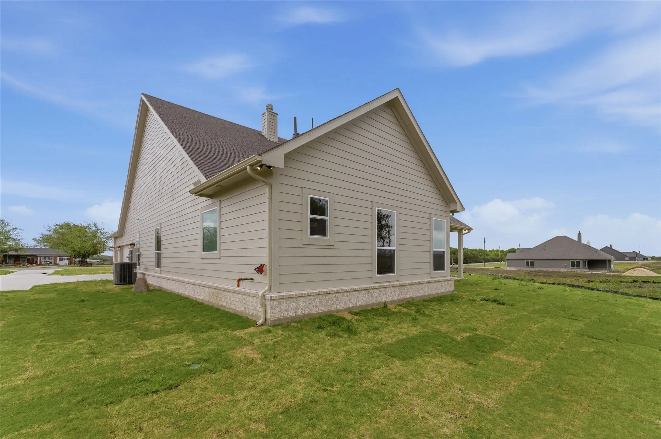 View of side of home featuring a lawn and a chimney